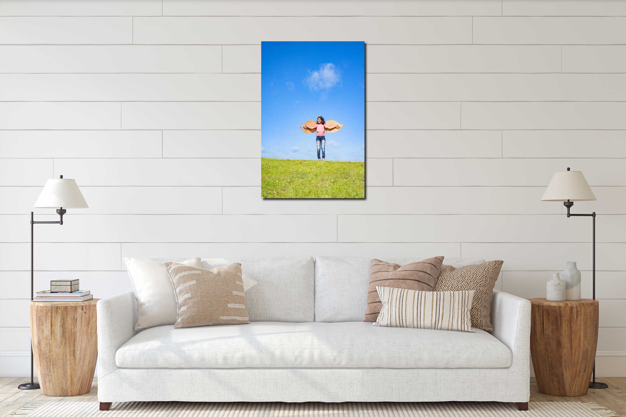 vertical shot, happy excited girl kid with artificial wings dancing like a bird on top hill in green meadow against blue interior mockup