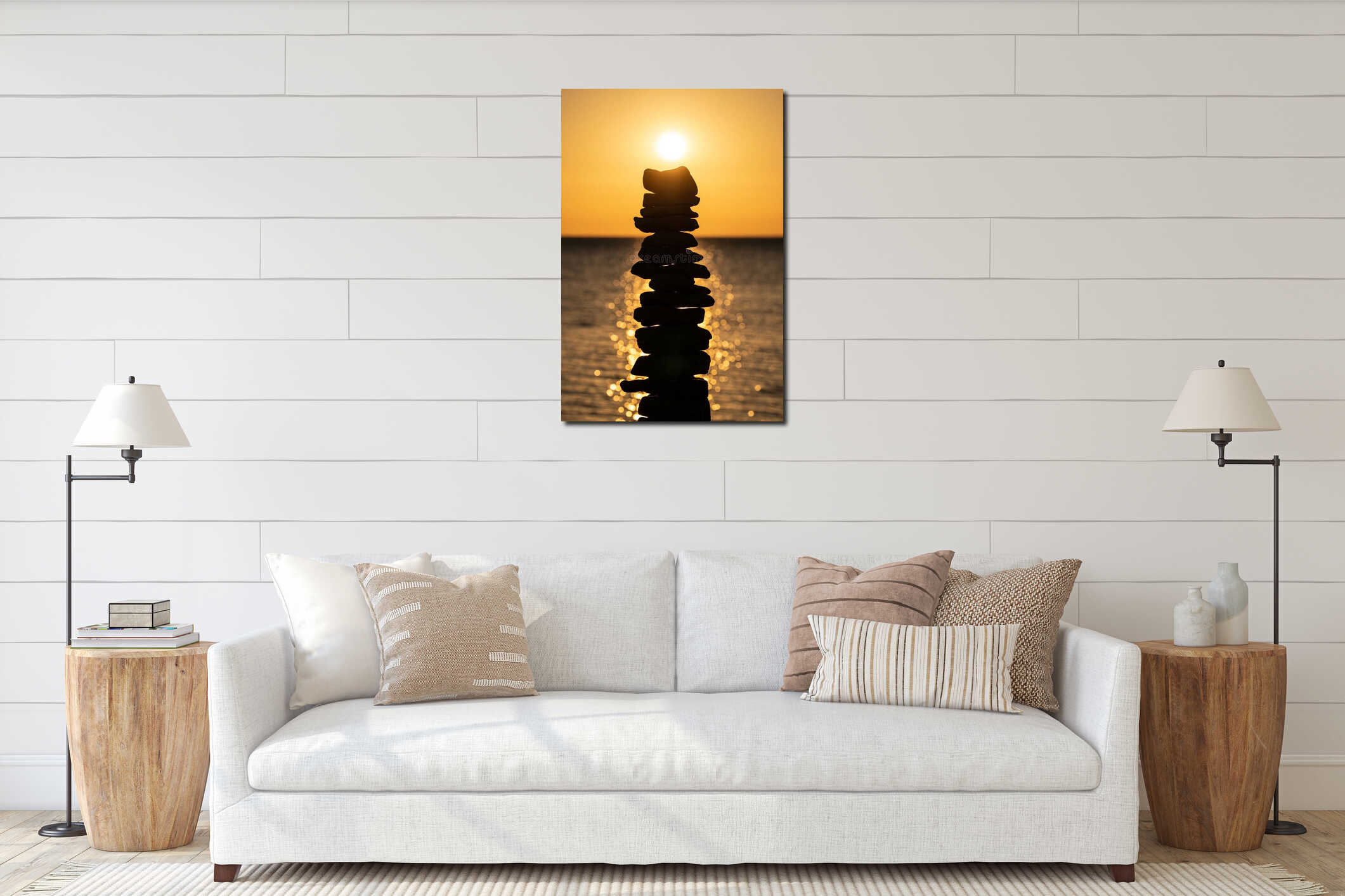 Vertical closeup shot of stacked stones against the sun and the glowing blue sea at sunset interior mockup