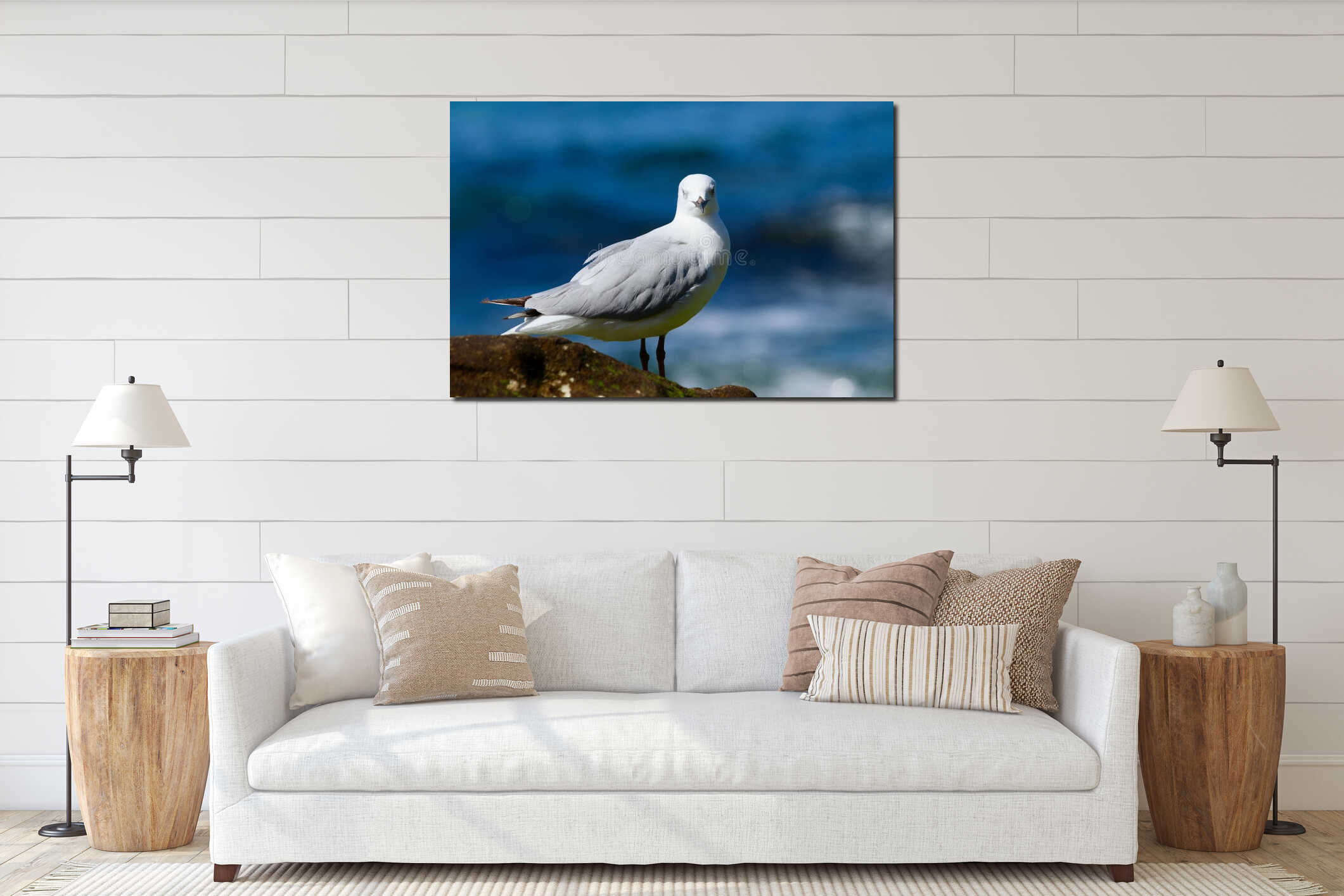 Isolated seagull perched on a rocky outcrop overlooking the sea. interior mockup