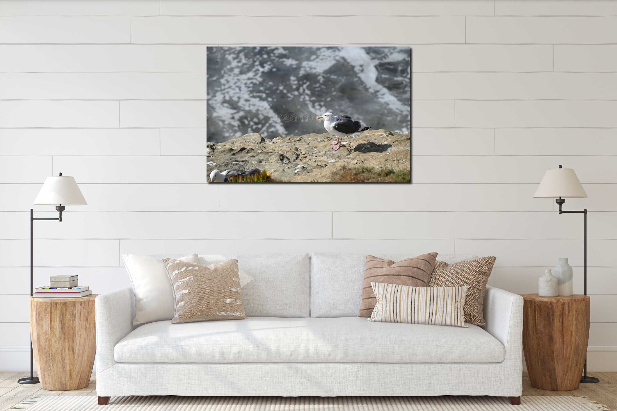Selective focus shot of a white seagull perched on a rocky shore interior mockup