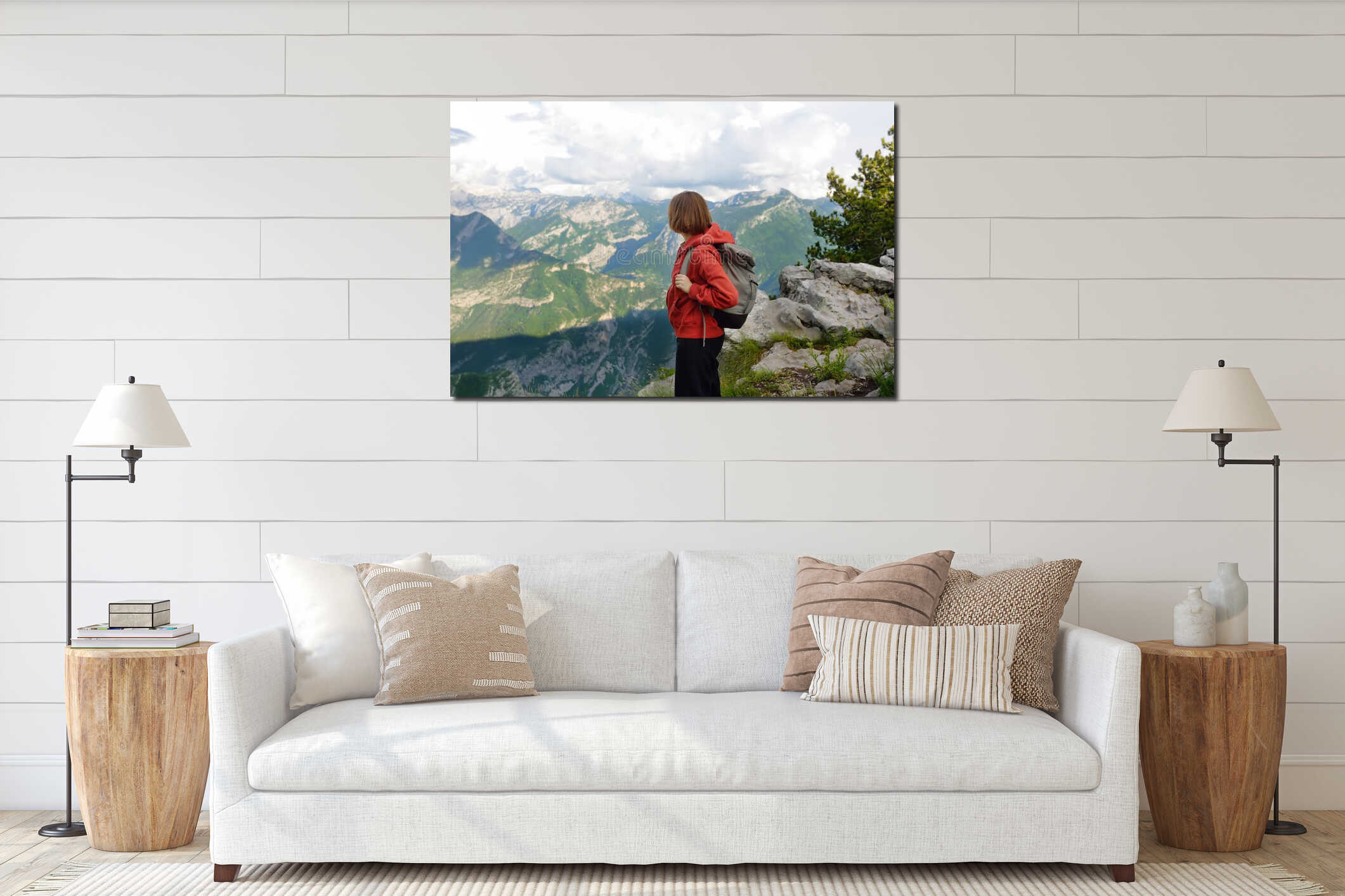 Side view of female hiker standing on stony slope of mountain valley during hiking trip. Young woman enjoying picturesque scenery interior mockup