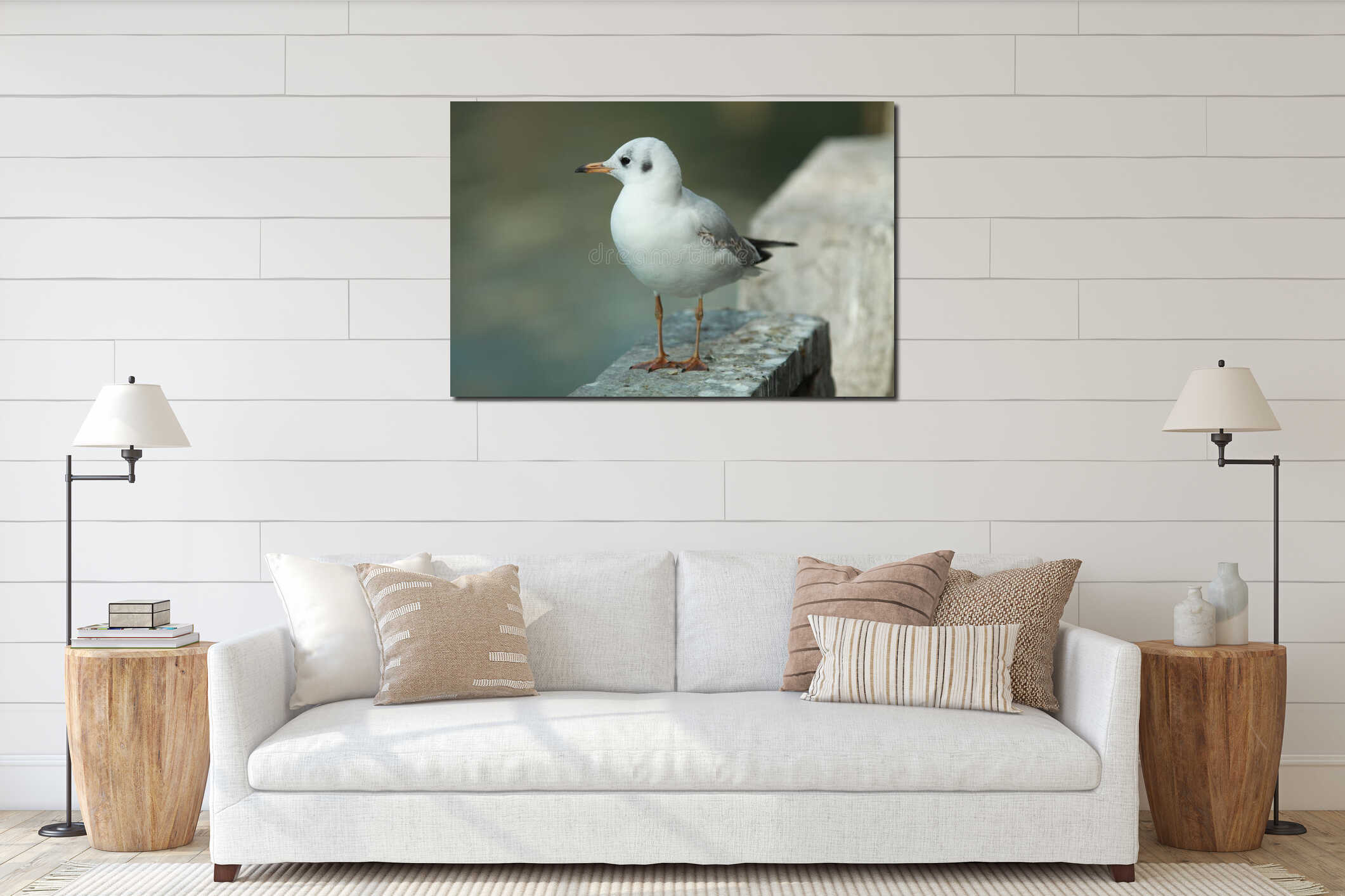 Small white seagull is perched solo on the edge of a brick wall interior mockup