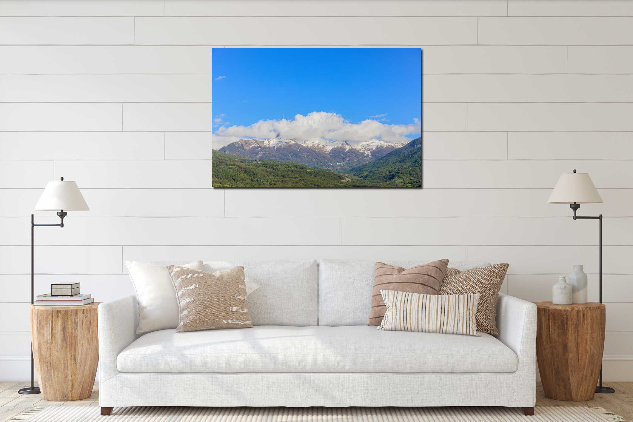 A scenics view of a green mountain valley with snowy rocky mountain summits under a majestic blue sky and some white clouds interior mockup