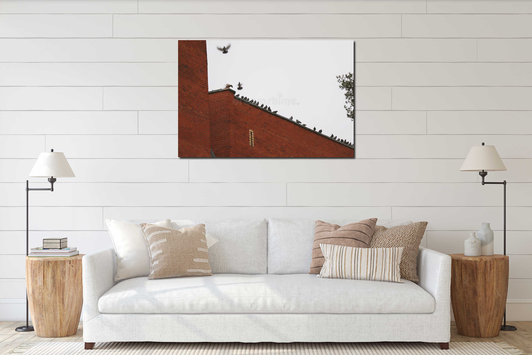 Silhouette of many pigeons on the roof of a red brick building with some flying birds on white sky background in town interior mockup