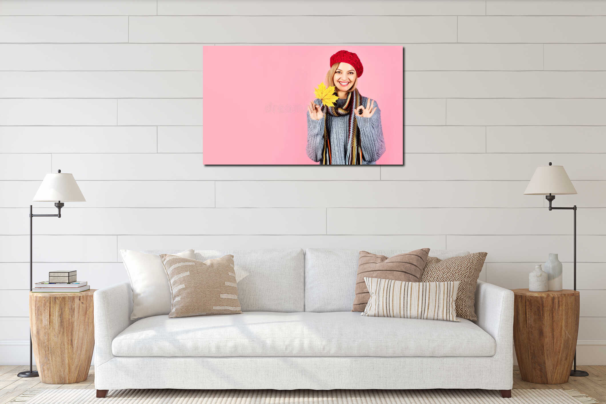 Smiling woman in warm clothes with maple leaf showing ok gesture. Beautiful girl in knitted sweater, scarf and red interior mockup