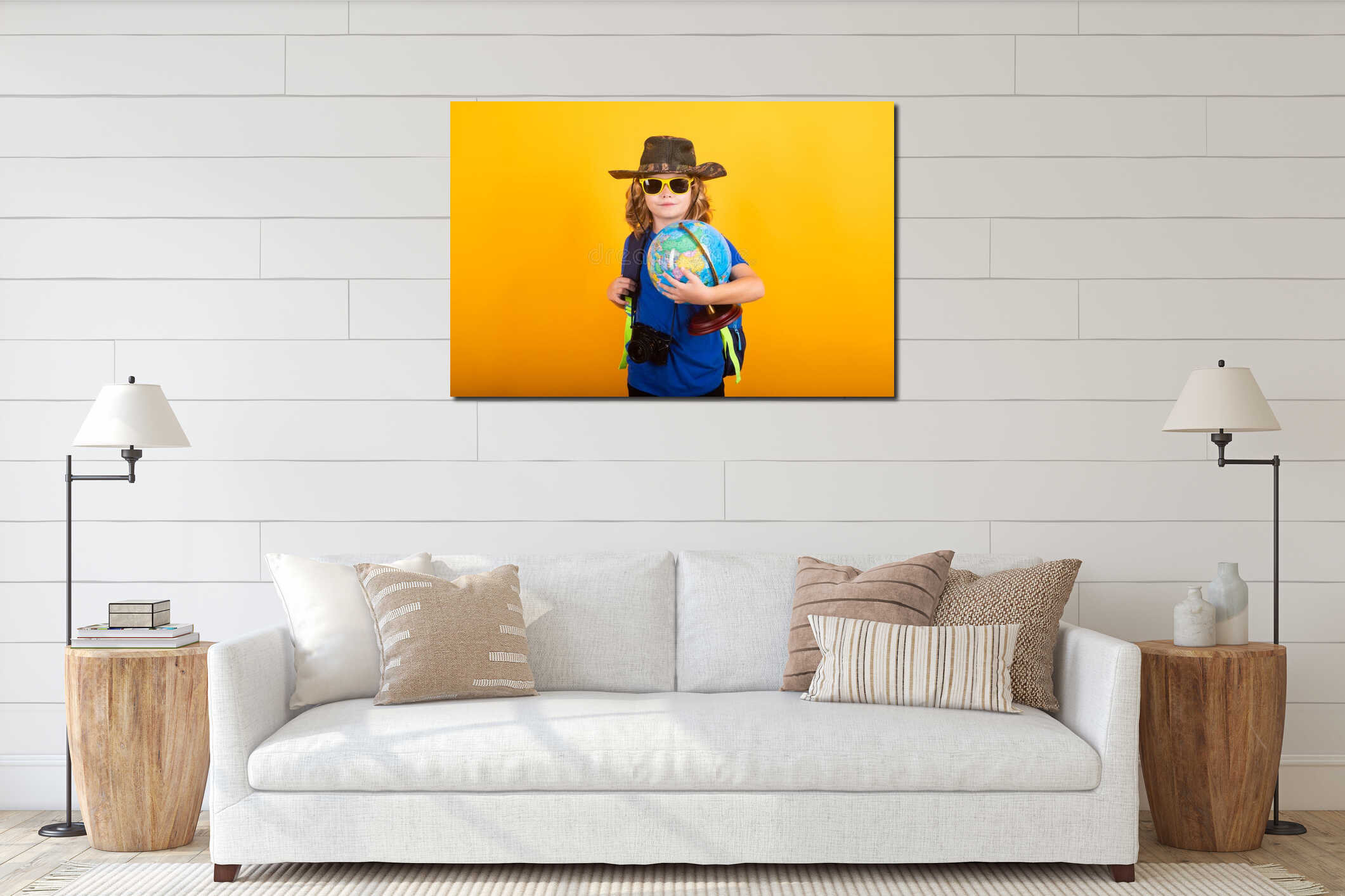 Studio portrait on a yellow background. Travel and adventure concept. Little child boy tourist explorer with globe world interior mockup