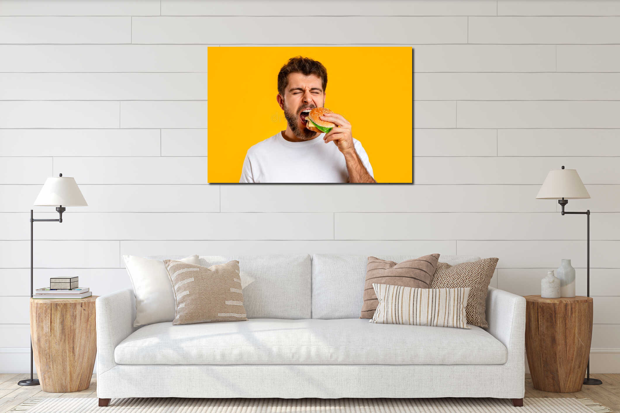 Funny man takes bite of tempting burger on yellow backdrop interior mockup