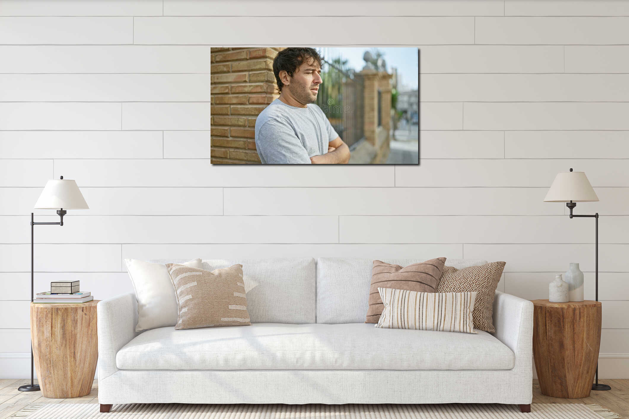Relaxed young man stands with a serious, concentrated expression on a busy city street, arms crossed in a casual gesture of interior mockup