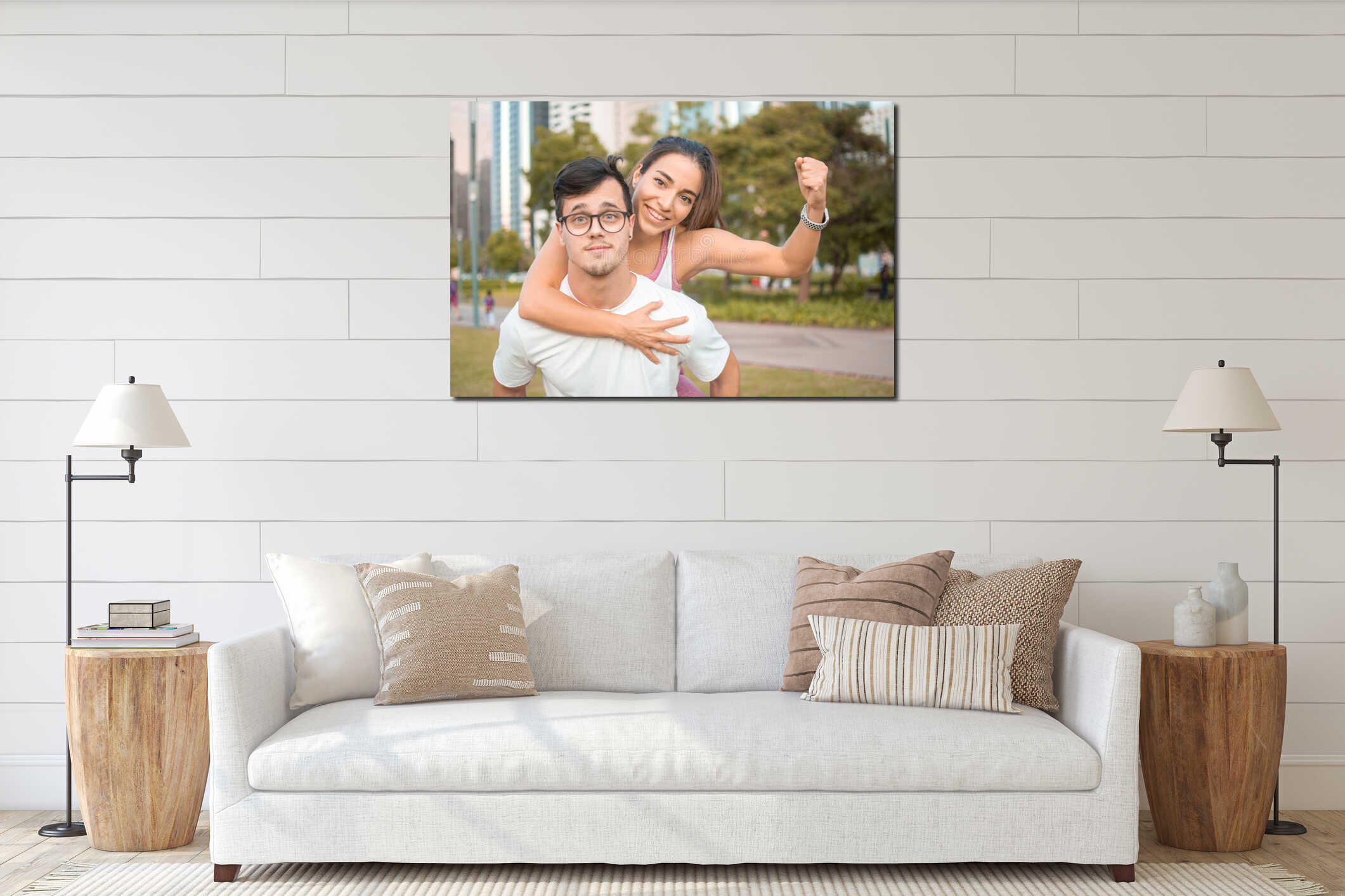 Handsome young man wearing eyeglasses carry on his back young woman flexing muscle with fist up outdoors. interior mockup