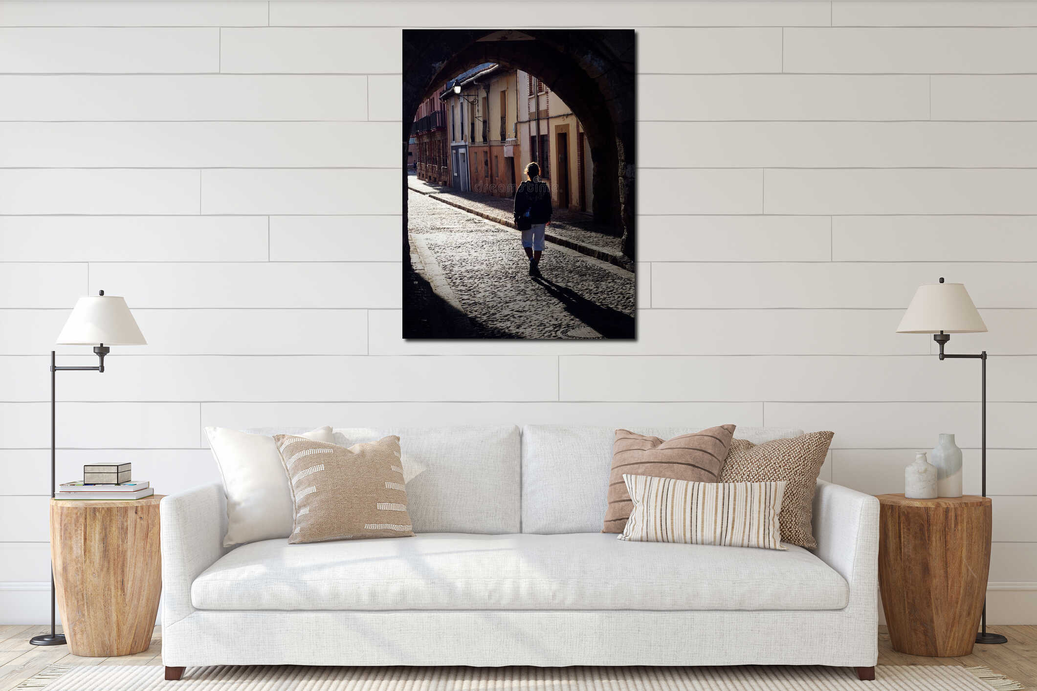 Vertical back shot of a person walking through a cobblestone street in a historic European town interior mockup
