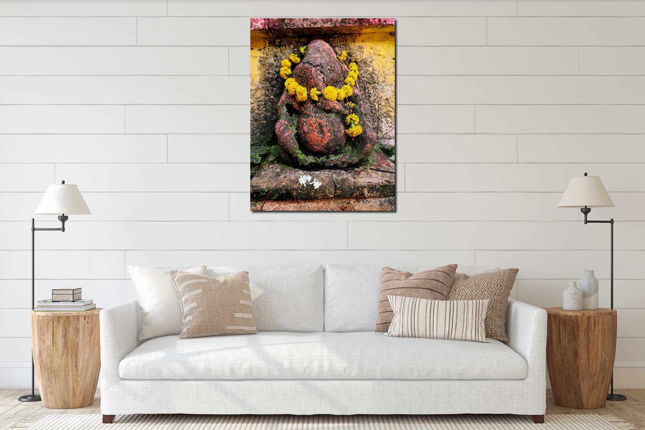 Stock photo of an old, rustic idol of lord Ganesha, painted with vibrant orange, is set against the backdrop of a large trees interior mockup