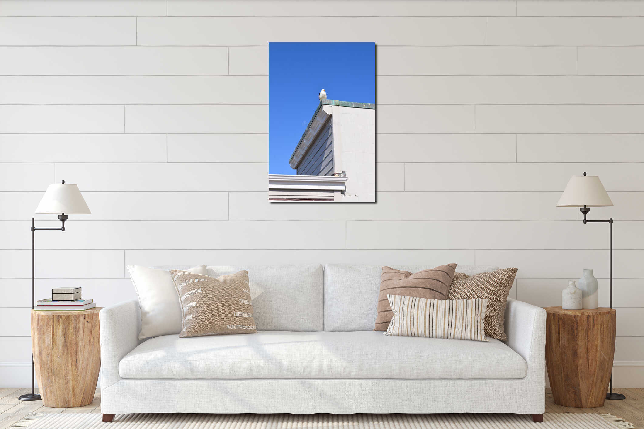 Vertical shot of a seagull perched on a rooftop of a house against blue sky interior mockup