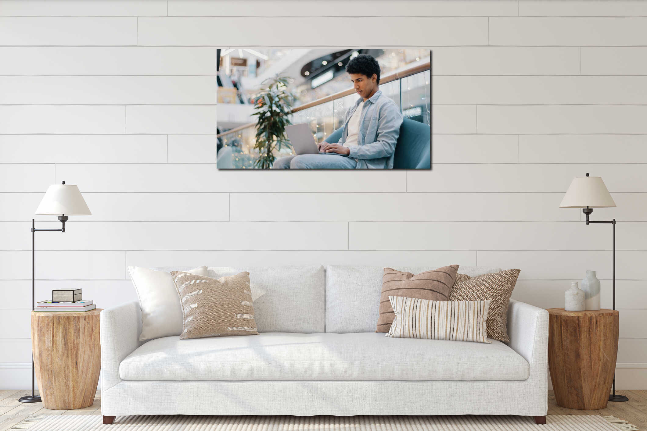 Relaxed serious busy millennial african ethnic student freelancer businessman using laptop device leaning on sofa in interior mockup