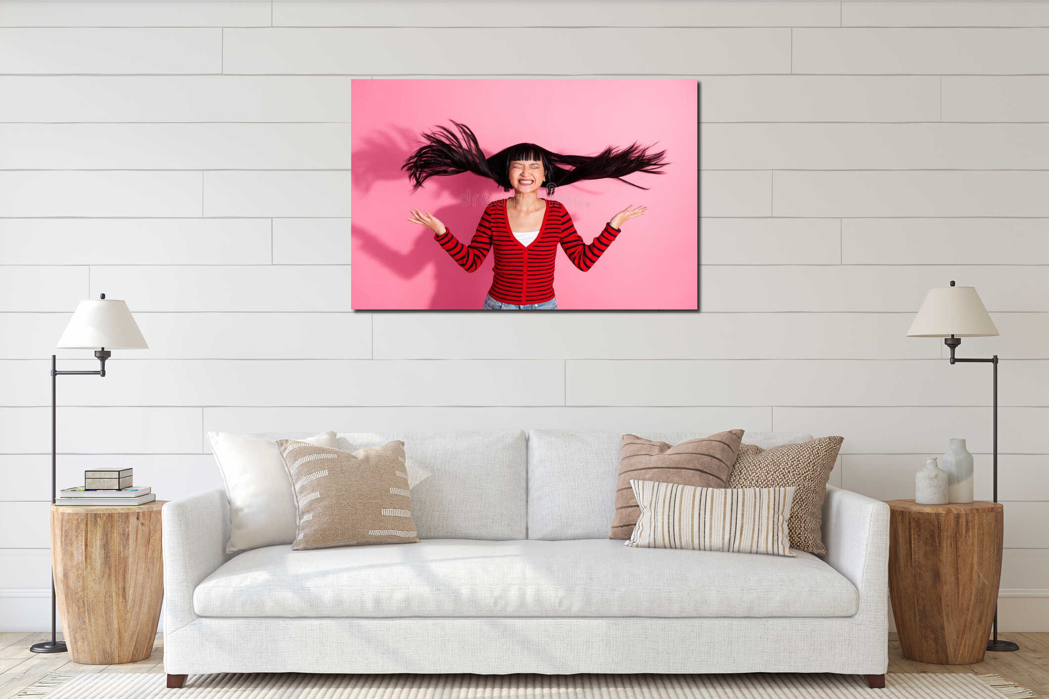 Excited young Asian woman with flowing hair and bright smile on pink background wearing striped red cardigan interior mockup