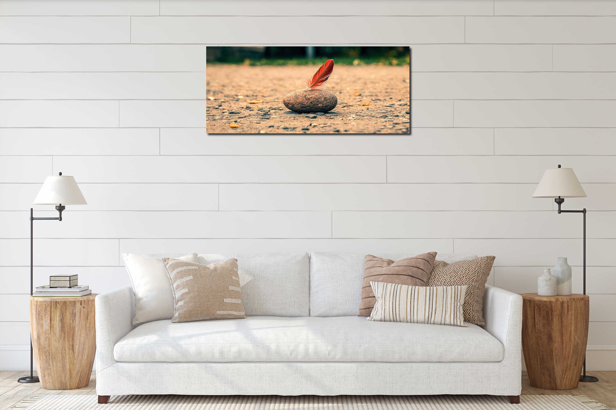 A single red feather rests on a rock in a field of dry leaves. interior mockup
