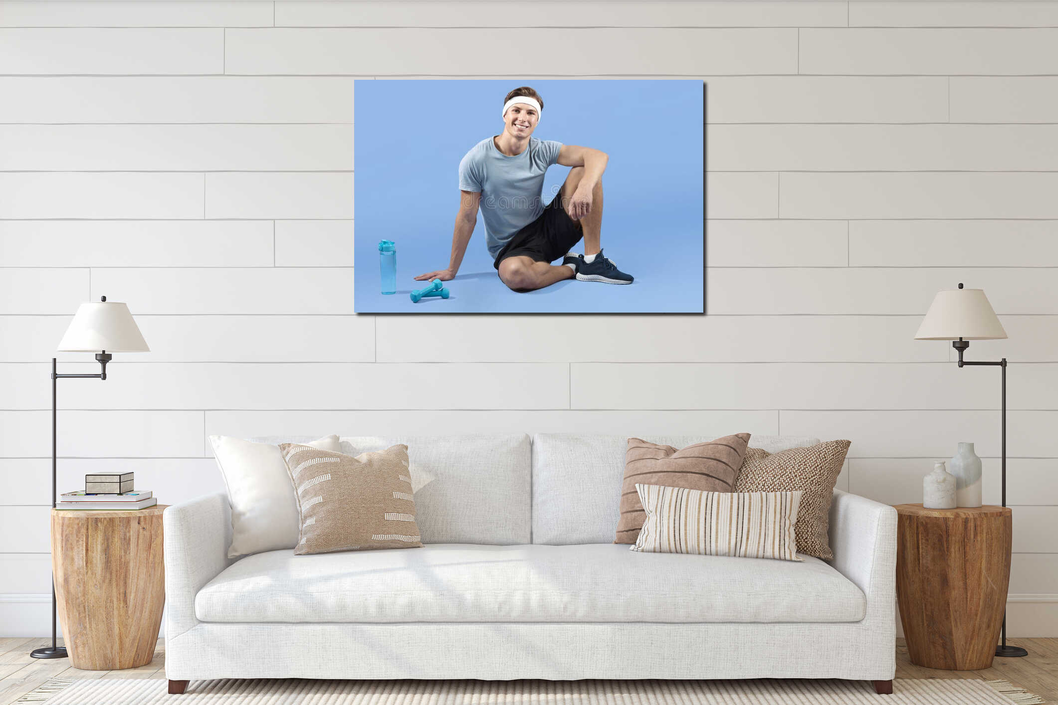 Full length portrait of young athletic man with dumbbells and bottle of water sitting on lilac studio background interior mockup