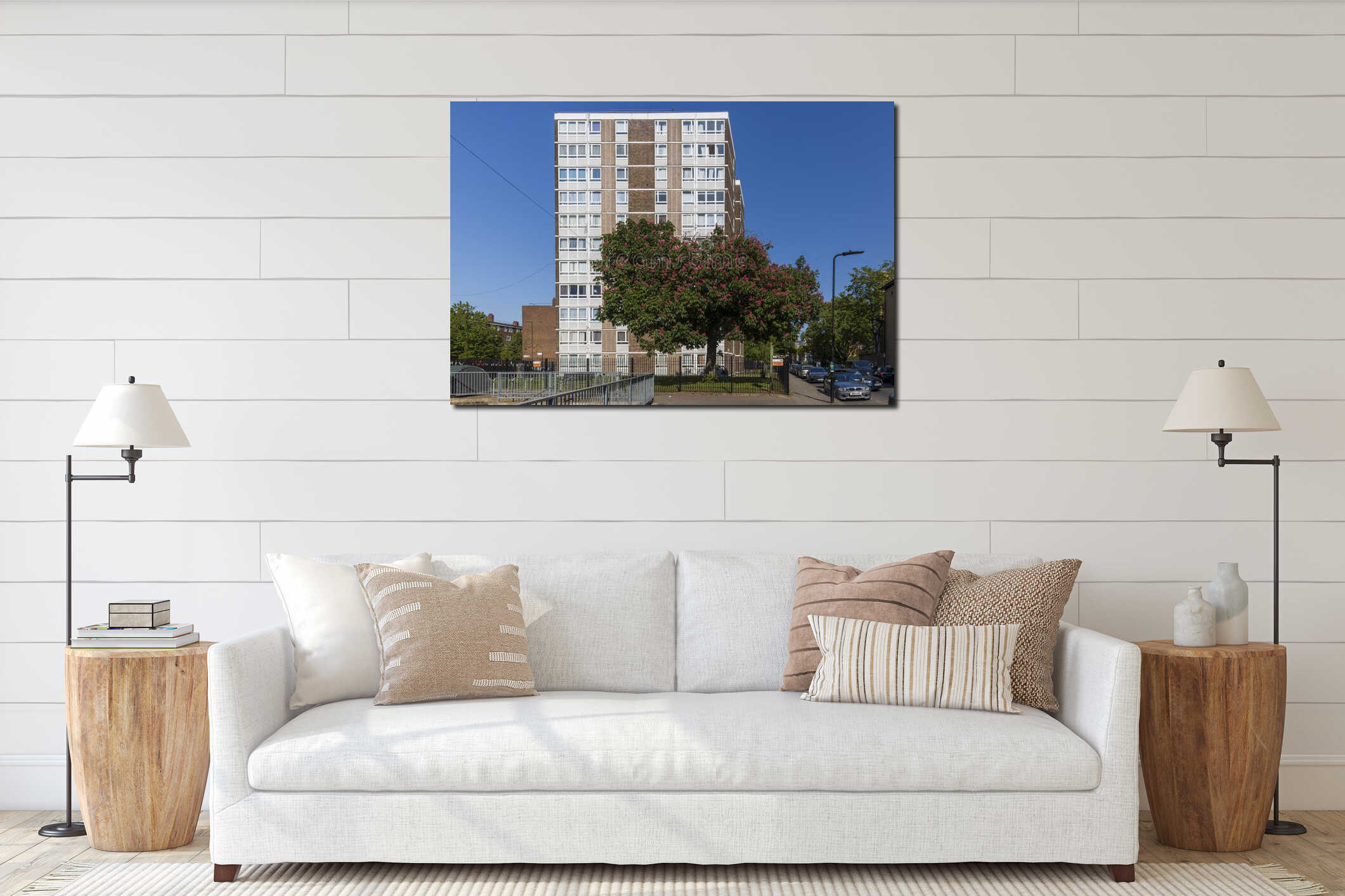 A tall residential tower block rises behind a blooming chestnut tree in a sunny urban landscape in interior mockup