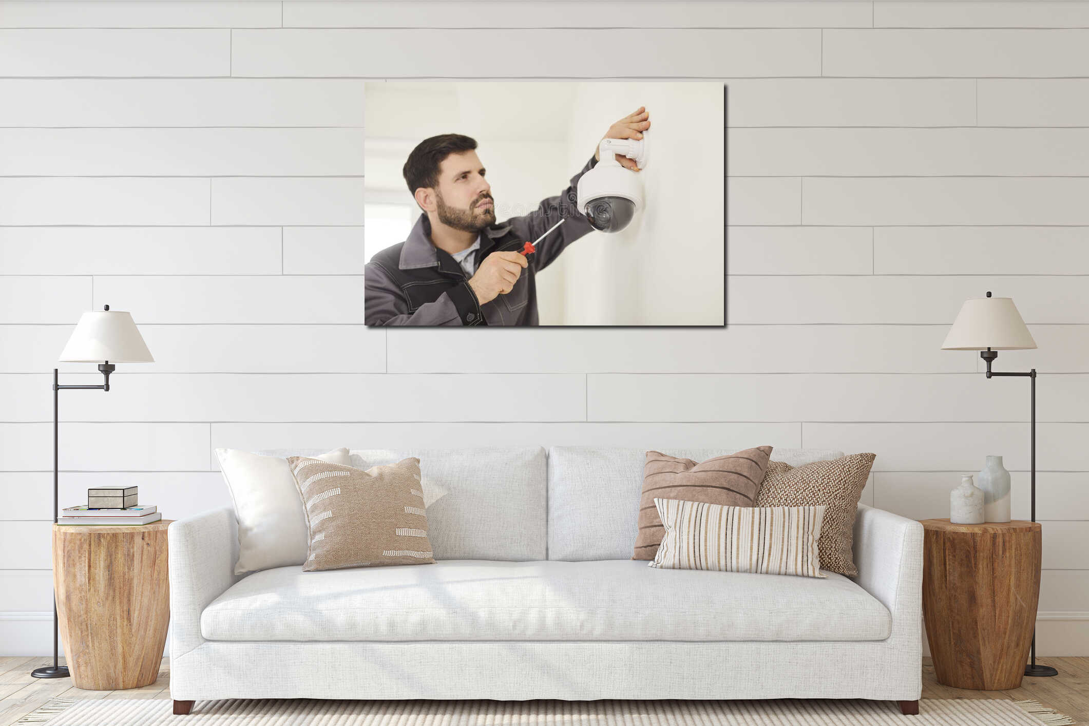 Portrait of young technician man installing surveillance CCTV camera on wall indoors. interior mockup