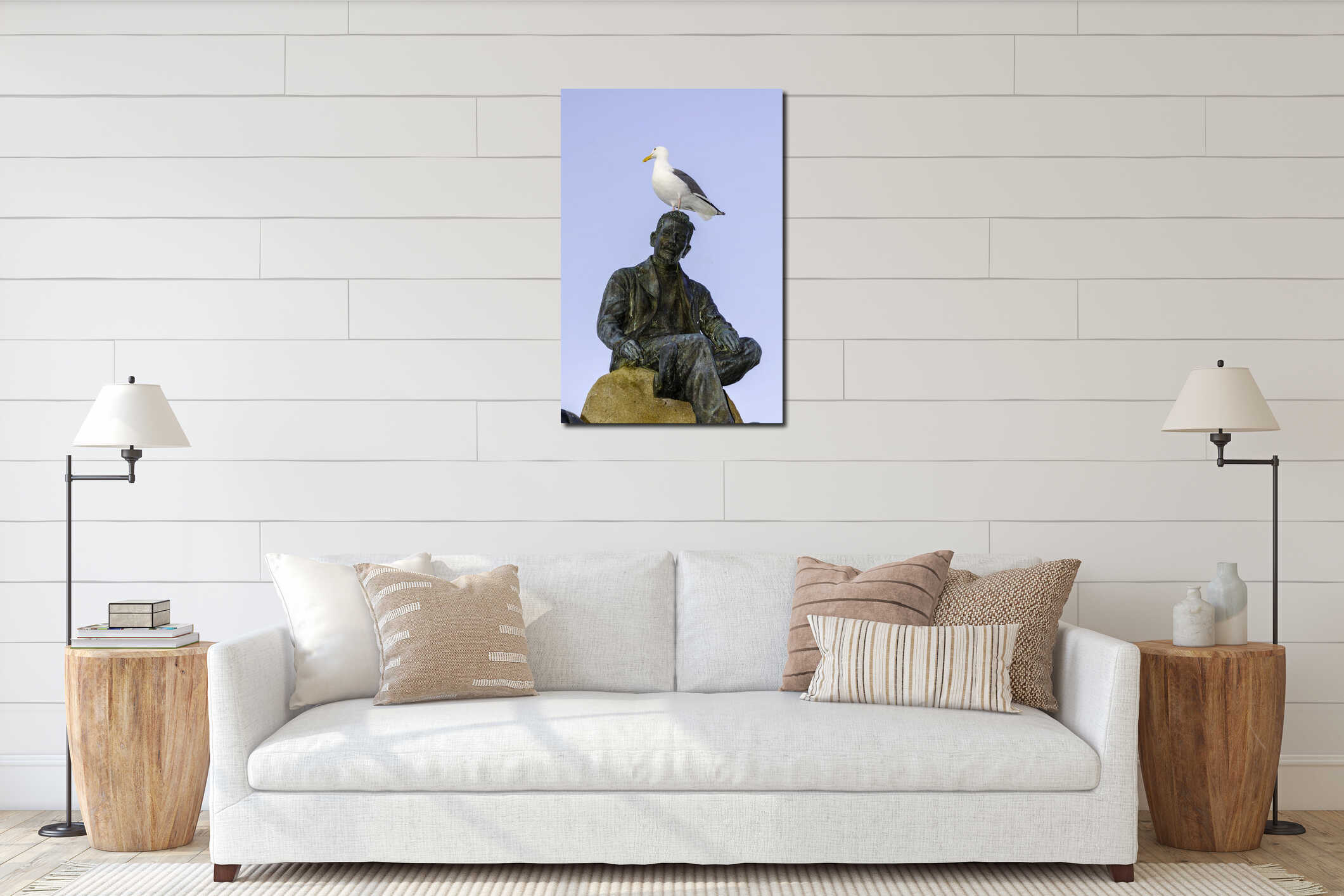 A white seagull with a yellow beak stands atop the head of a bronze statue. interior mockup