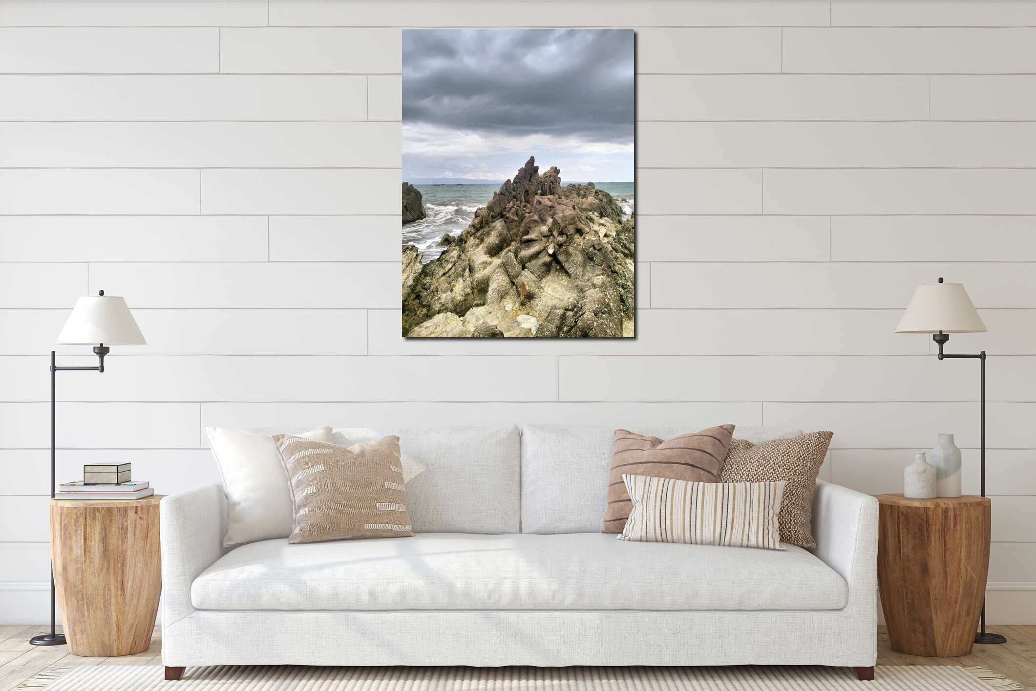 Jagged coastal rocks face the crashing waves beneath a dramatic sky, where dark clouds gather above the calm horizon of the sea. interior mockup