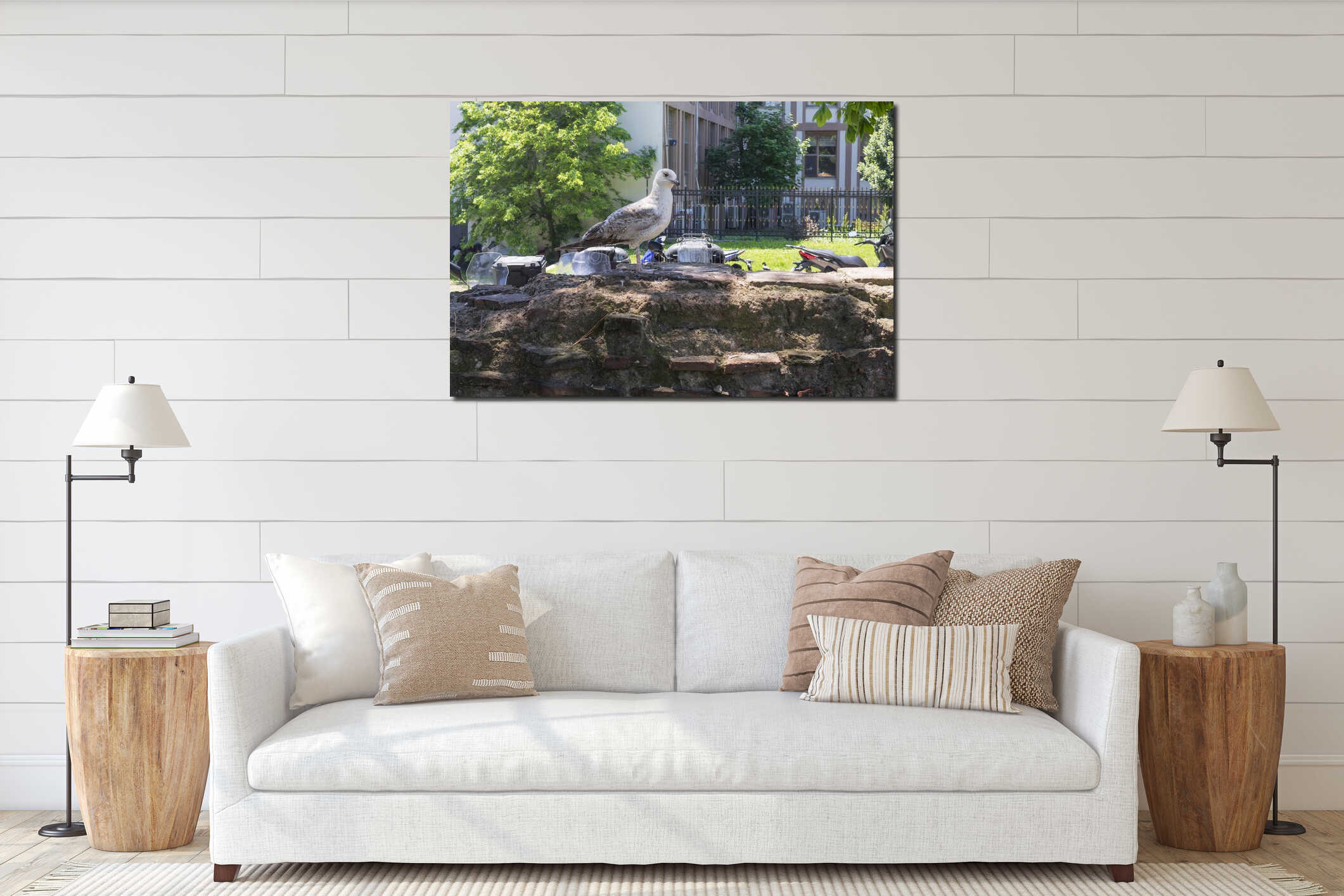 Urban seagull on a stone wall in sunny park with motorcycles and trees in background interior mockup
