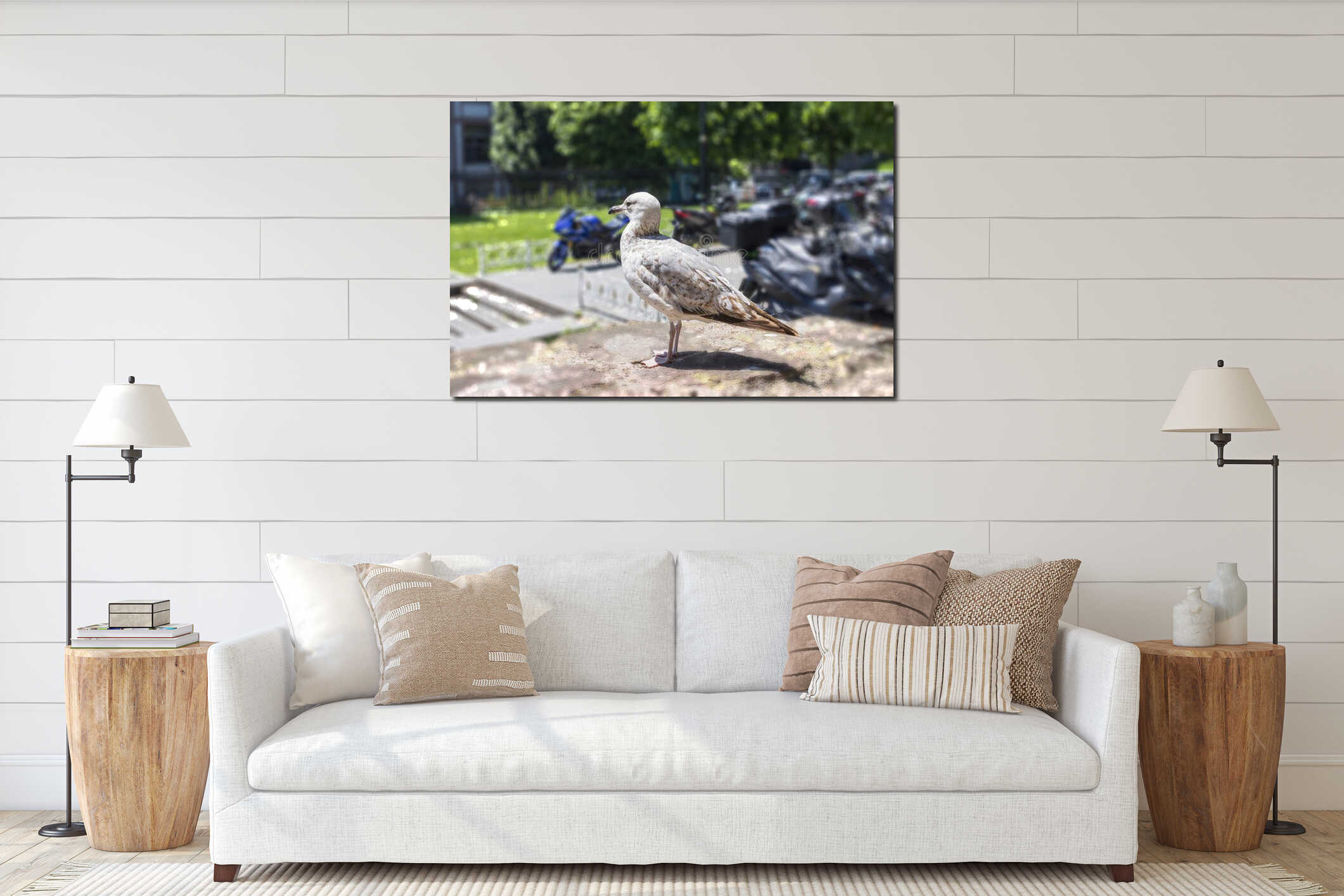 Urban seagull on a stone wall in sunny park with motorcycles and trees in background interior mockup