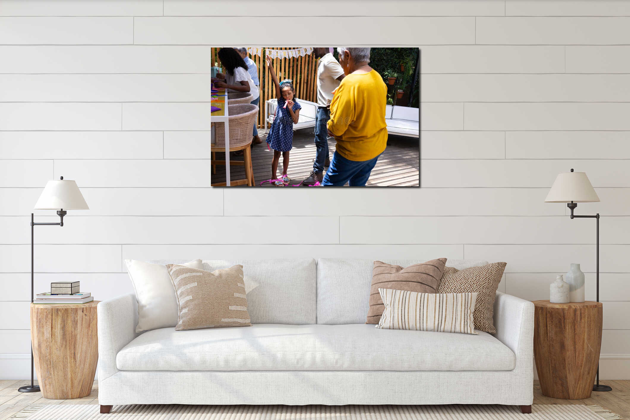 Young girl celebrating birthday with family outdoors, wearing party hat and smiling interior mockup