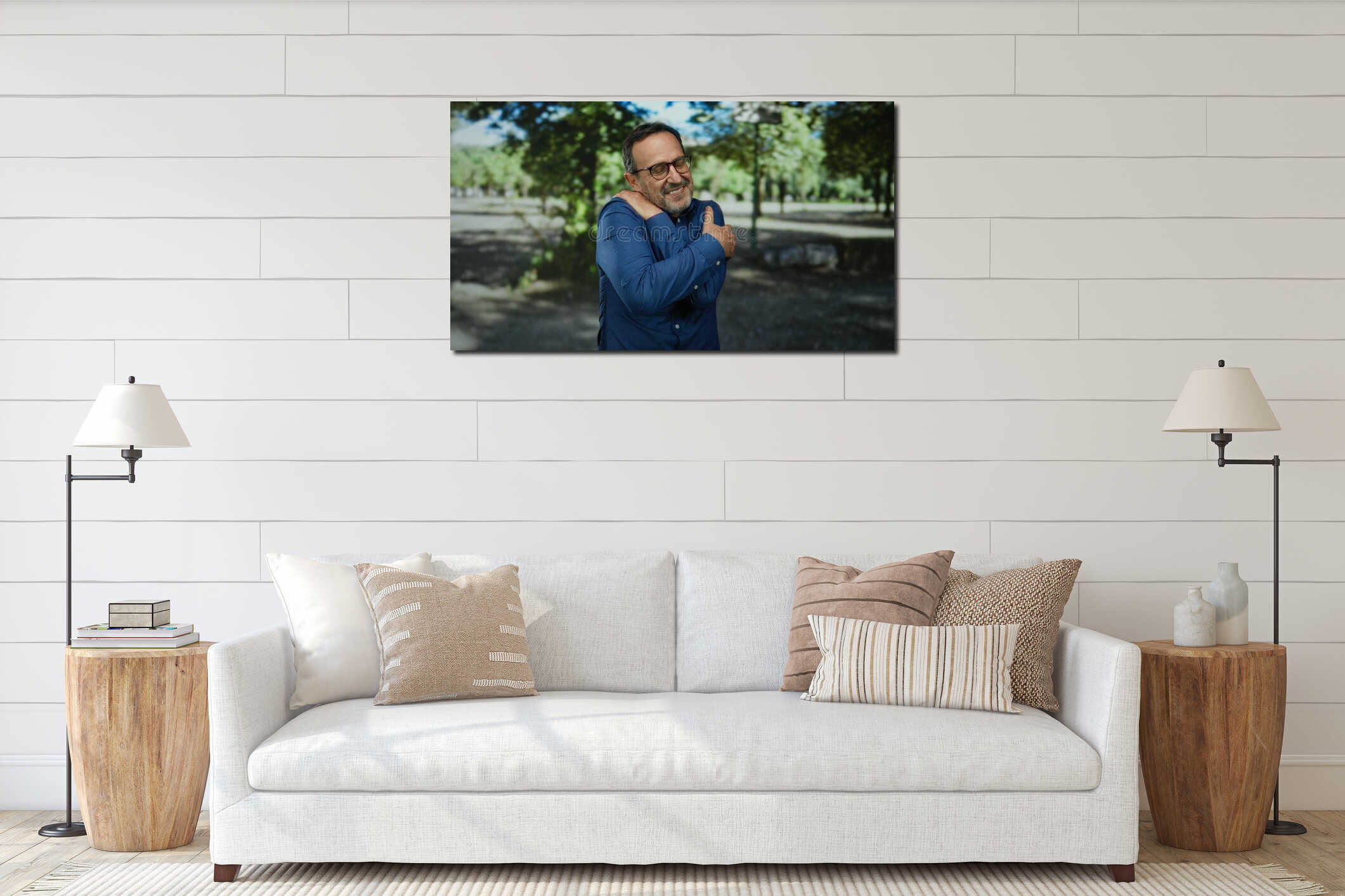 Hispanic man embracing self in a serene park setting on a sunny day, exuding calmness and mature wisdom, surrounded by lush green interior mockup