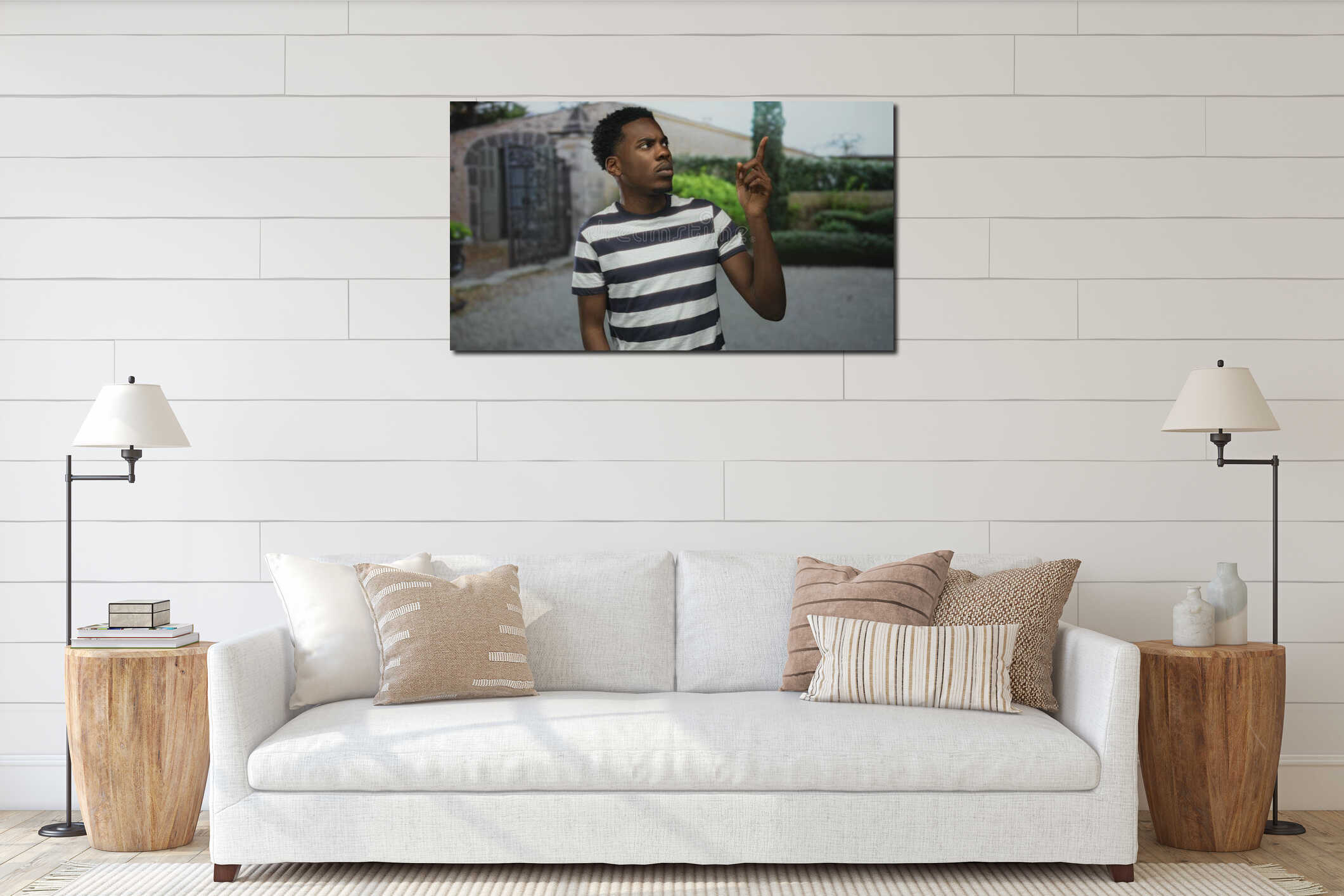 Young african american man in navy and white striped shirt points finger at ornate metal gate of stone building entrance under interior mockup