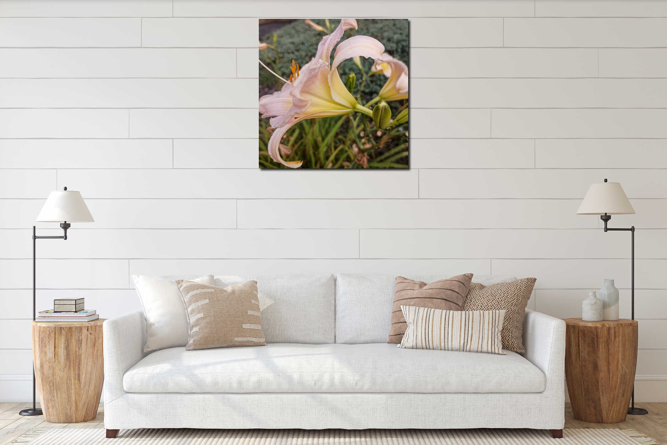 Side view of two pink and yellow lily flowers on a stem with four new buds and other stems with green leaves in the background. interior mockup