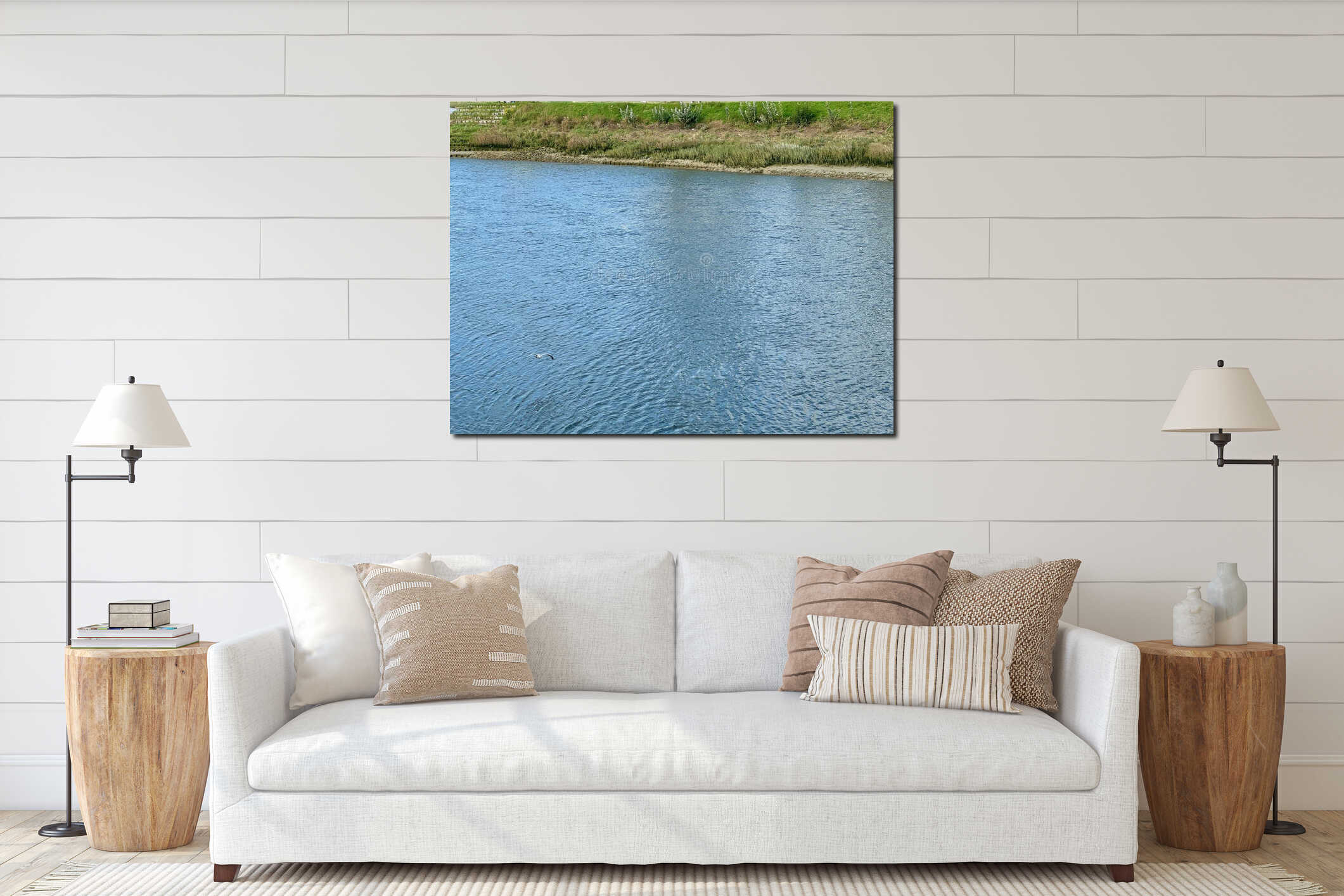 Seagull flying gracefully above the calm blue waters of the Somme Bay in northern France, near Le Crotoy, surrounded by grassy interior mockup