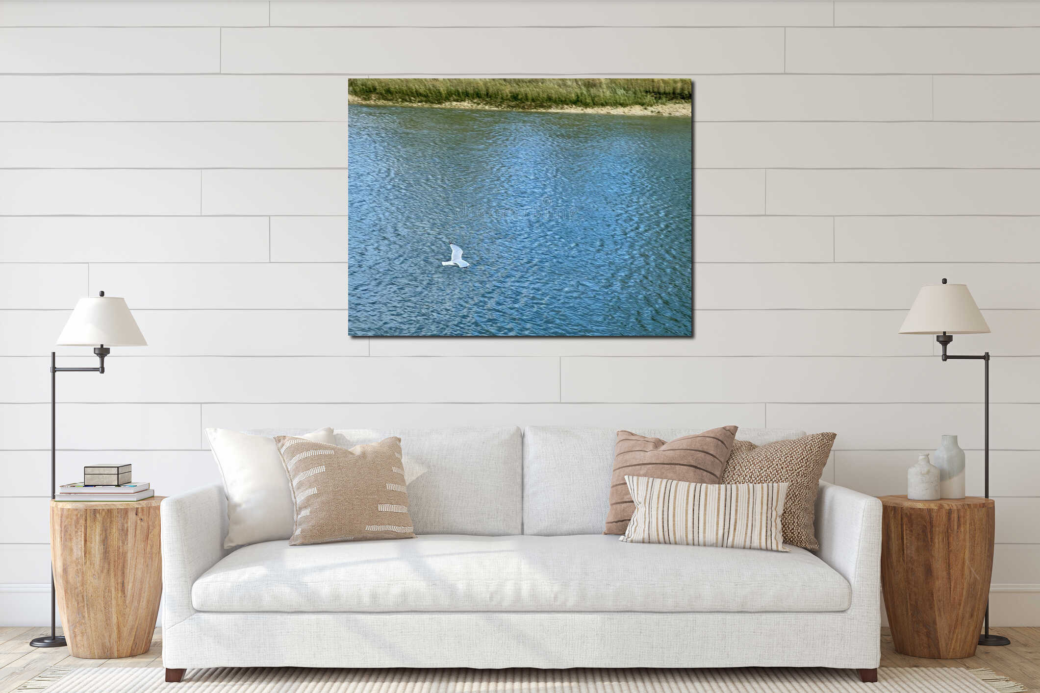 Seagull flying gracefully above the calm blue waters of the Somme Bay in northern France, near Le Crotoy, surrounded by grassy interior mockup