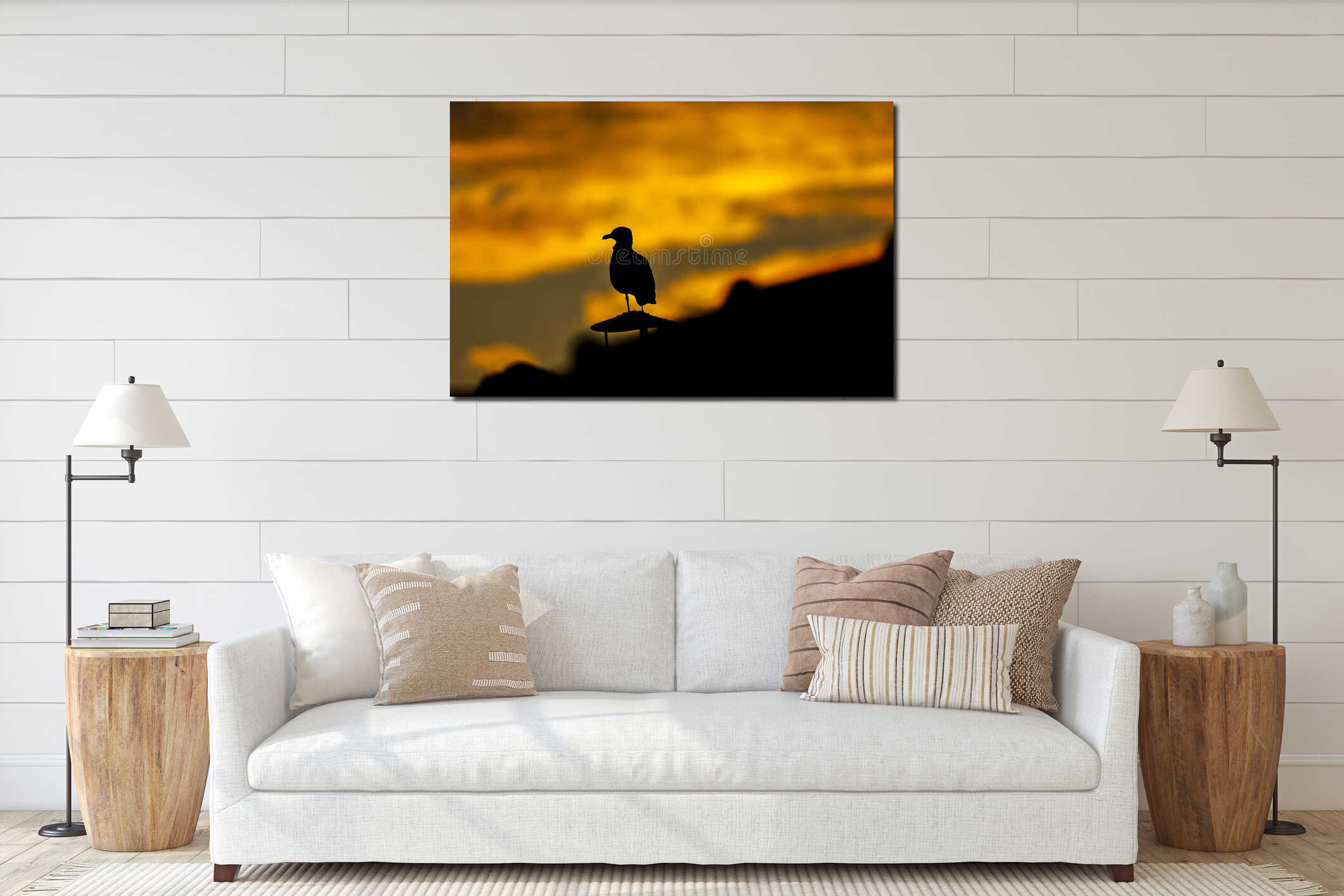 Silhouette of a seagull perched on rooftop against dramatic sunset sky interior mockup