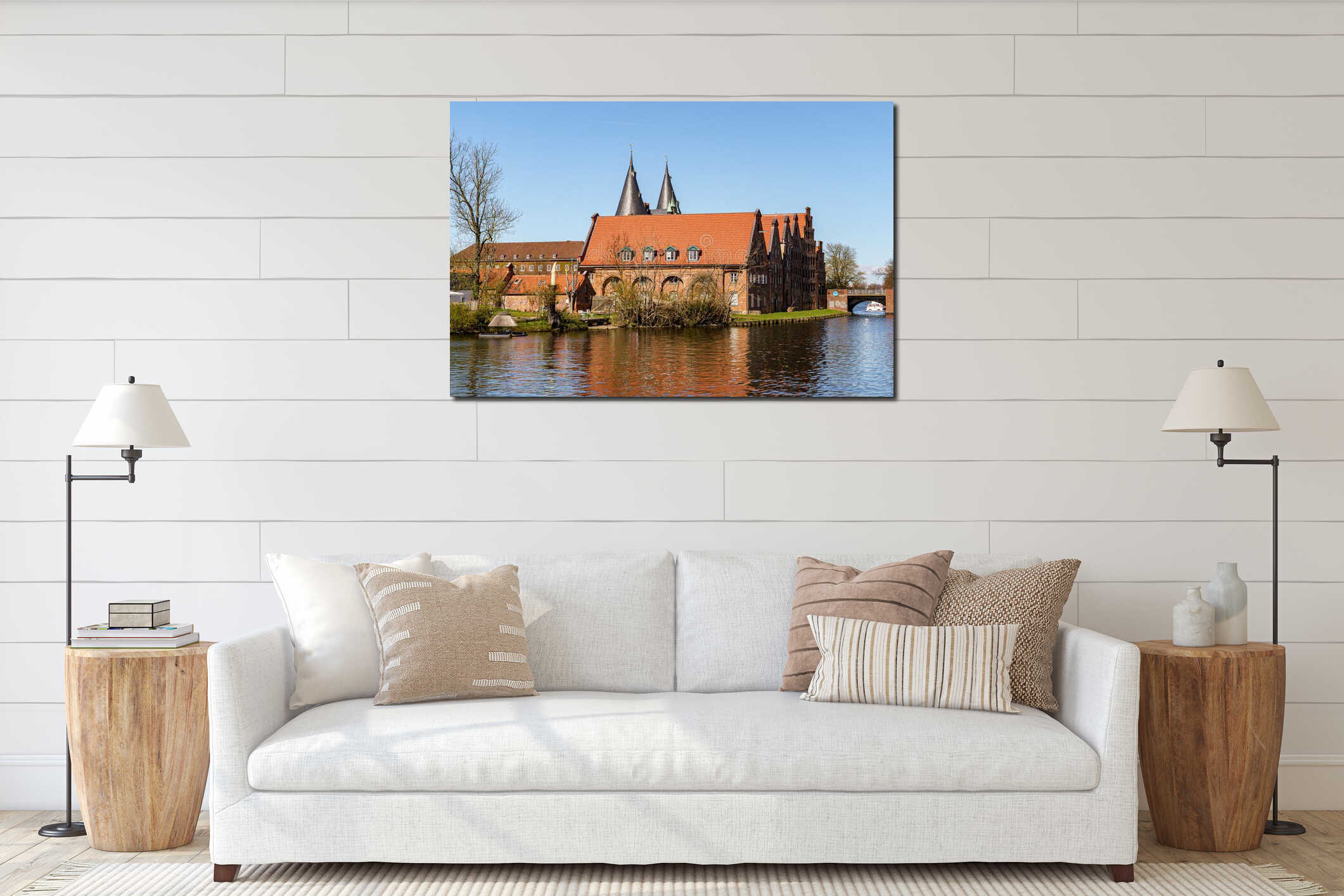 A large red building with a green roof sits on a river bank in Lubeck Germany The building has a steeple and a clock tower. The interior mockup