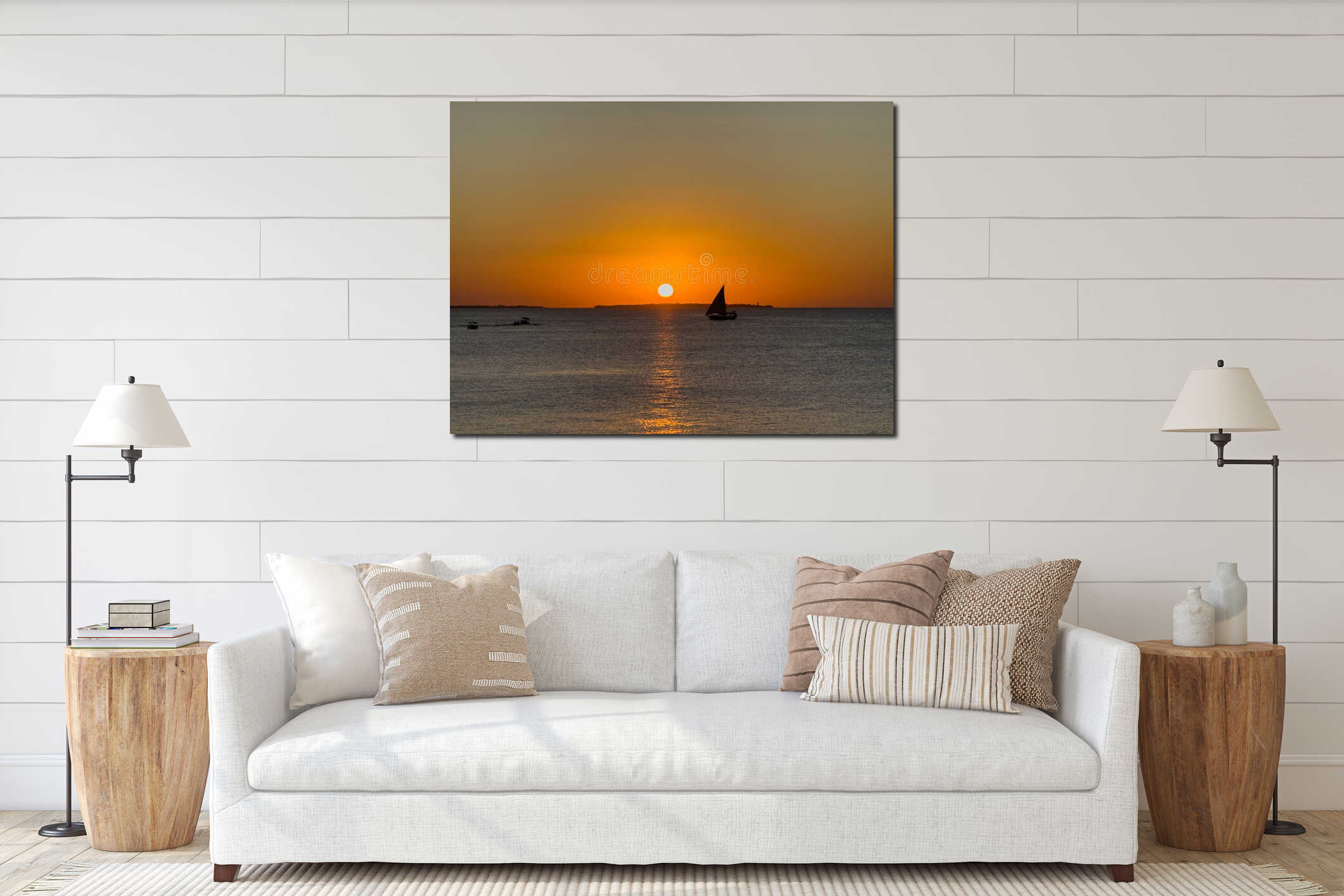 A traditional sailing boat sails on the sea in front of a golden sunset interior mockup