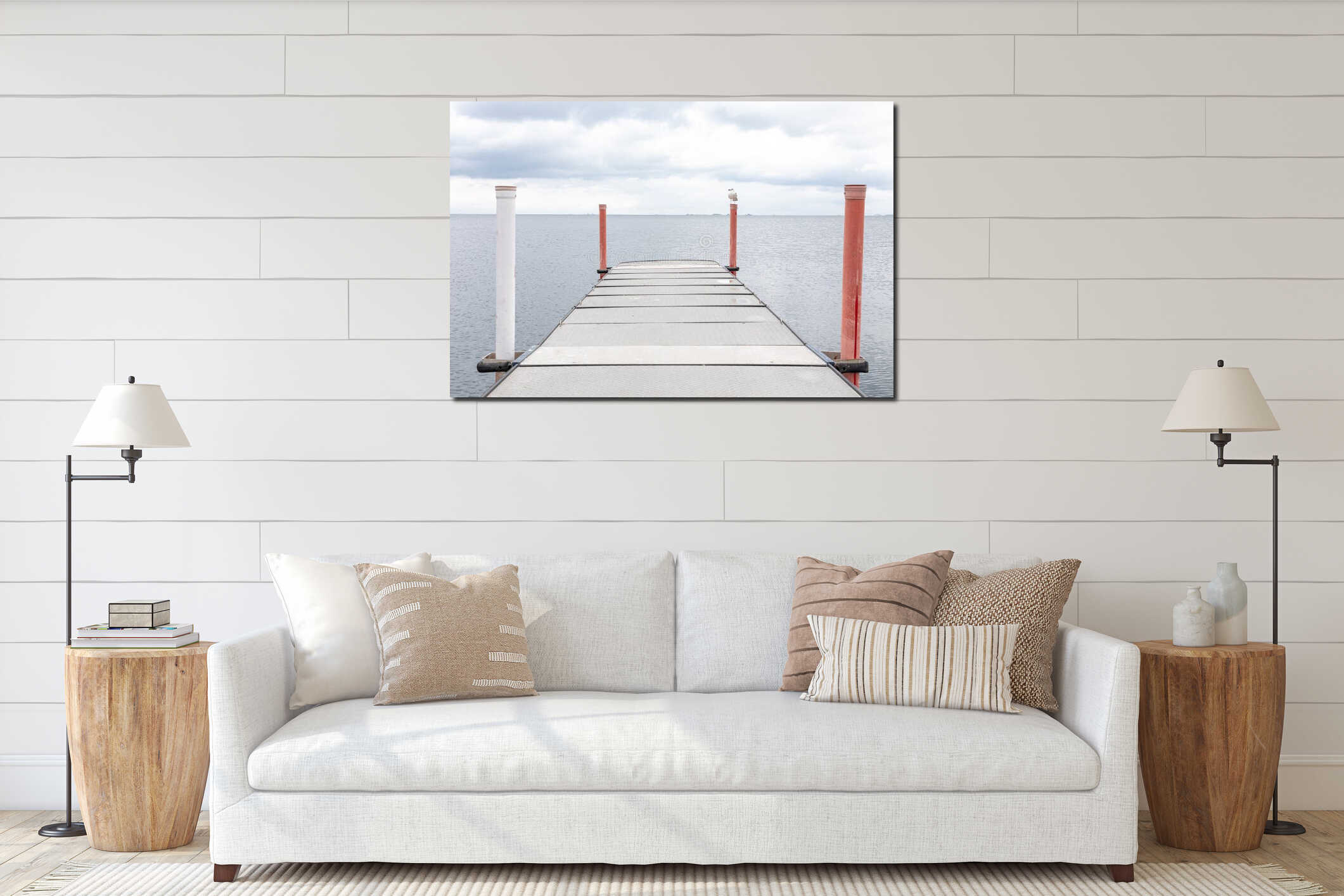Metal pier extends over calm water under cloudy sky with seagull beside posts interior mockup