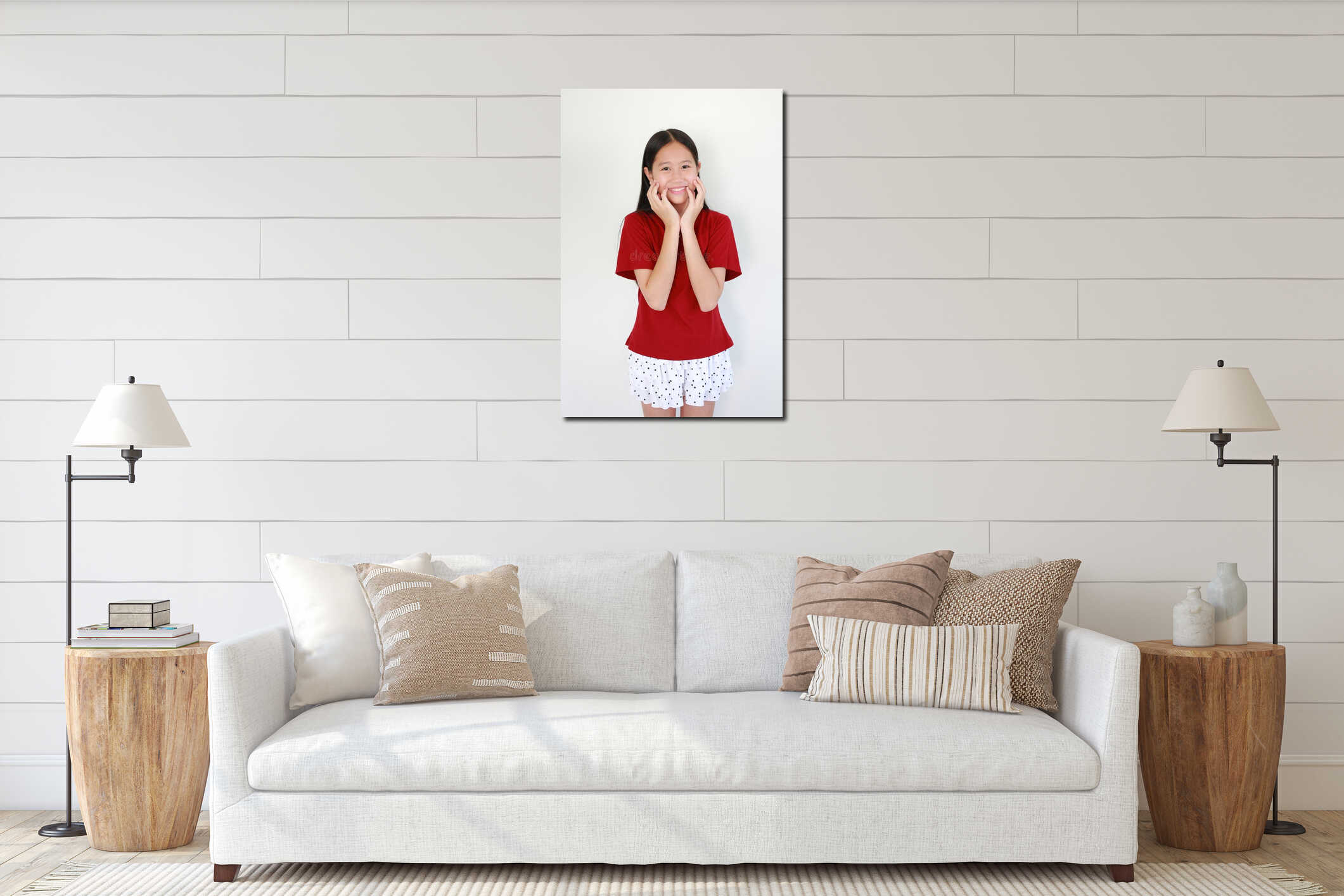 Portrait cheerful young Asian girl in red t-shirt smiling brightly while posing with her hands on her cheeks against white interior mockup