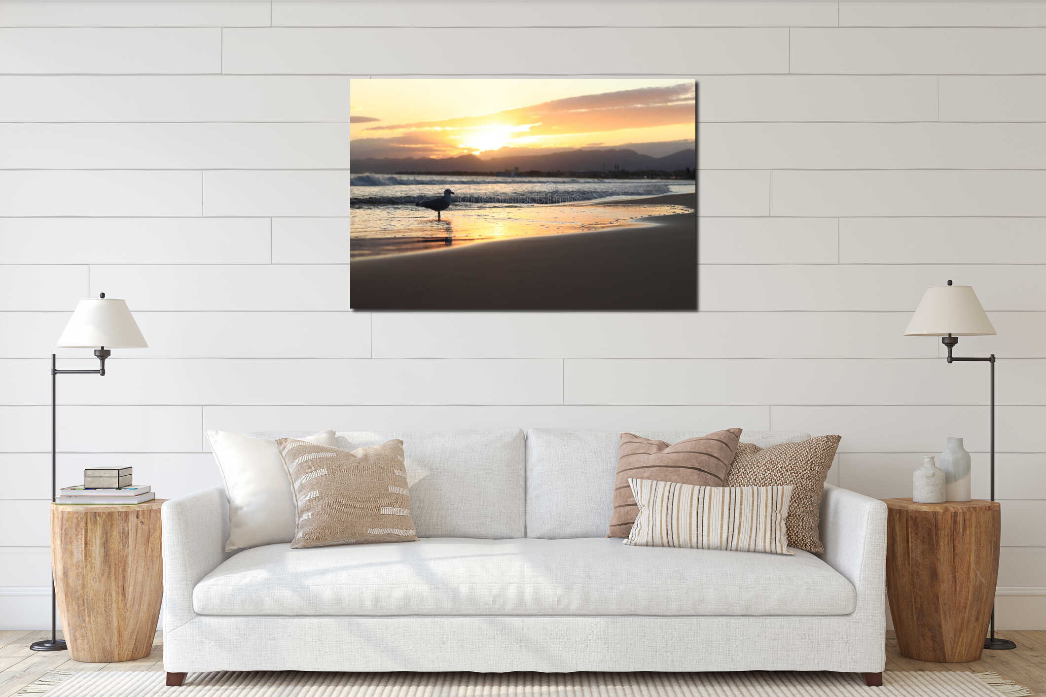 In the foreground, a seagull standing in a coastal wave. Sunset on the beach interior mockup