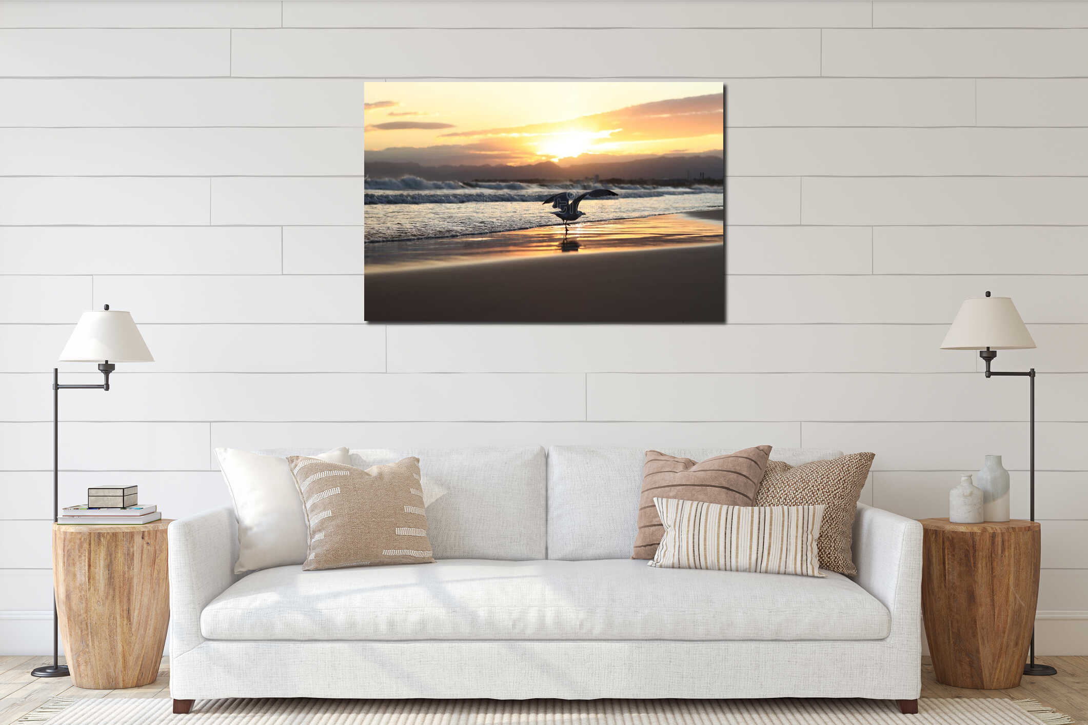 In the foreground, a seagull standing in a coastal wave. Sunset on the beach interior mockup