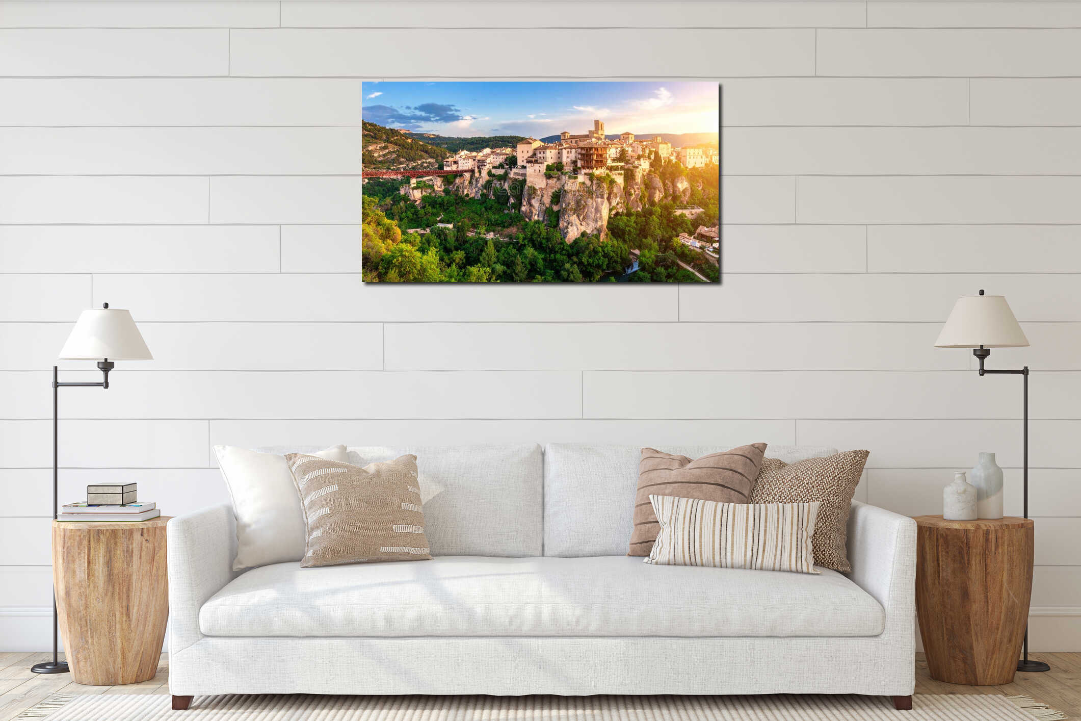 Scenic view of a historic cliffside town with buildings, bridge, and lush greenery at sunset interior mockup