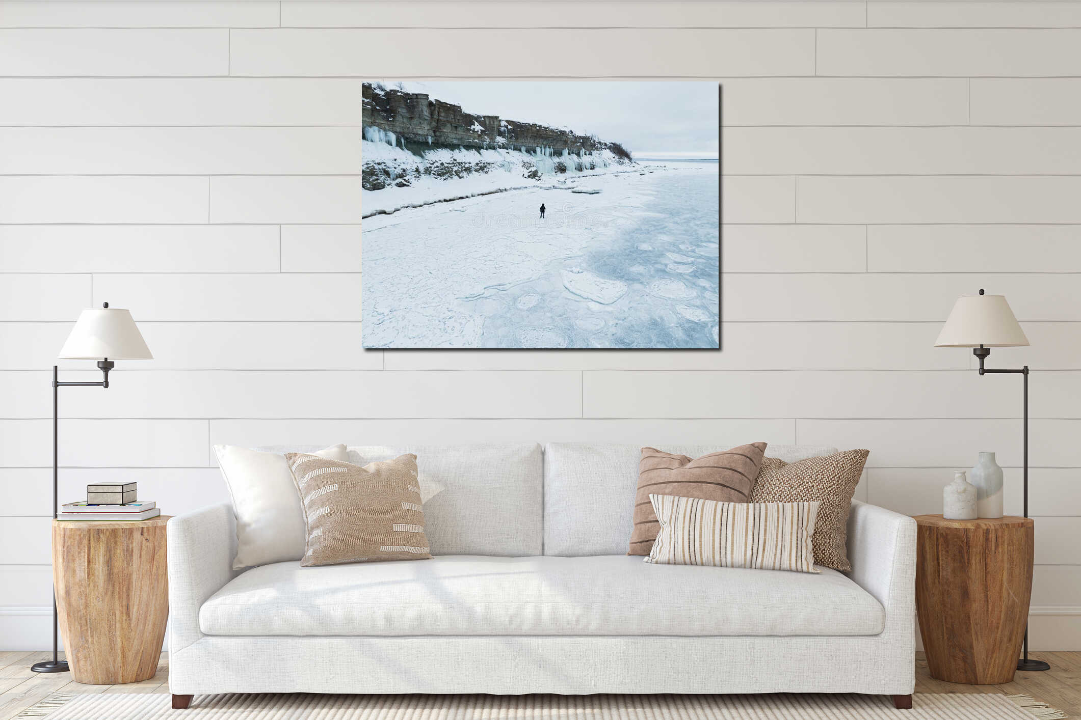 Aerial drone view of a lonely man walking on frozen sea ice near high limestone cliffs with icicles in Paldiski interior mockup