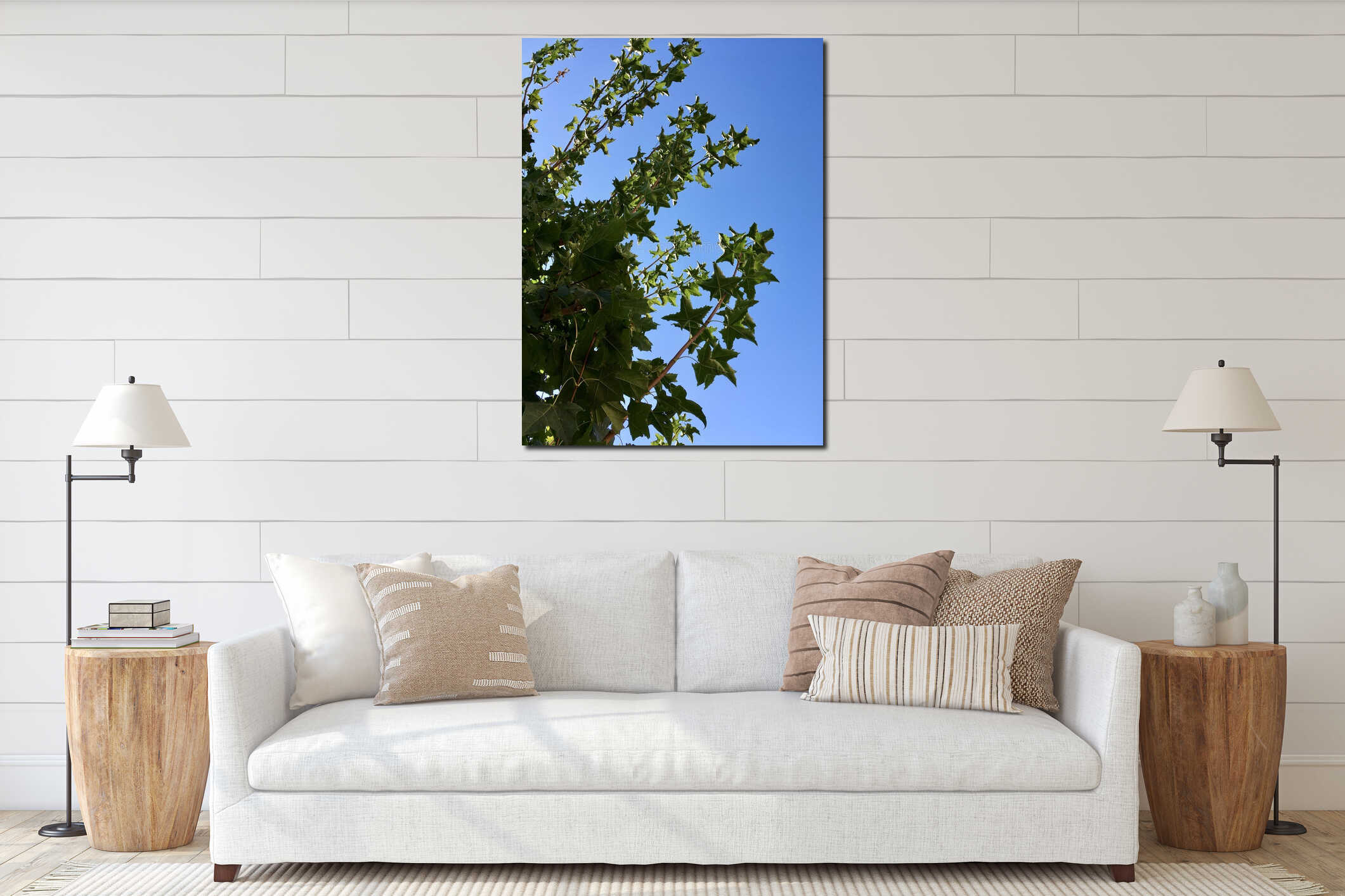 Thin maple branches with dark-green leaves reaching high light-blue clear cloudless sky vertical low-angle photo for natural, interior mockup