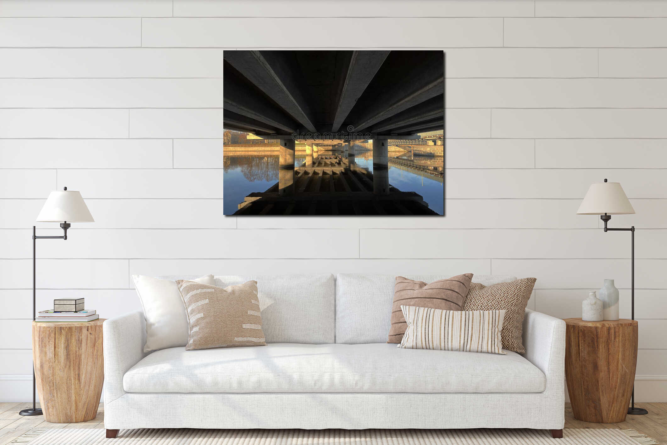 Underneath view of a concrete bridge with massive beams and pillars reflected in calm water, creating a symmetrical perspective interior mockup