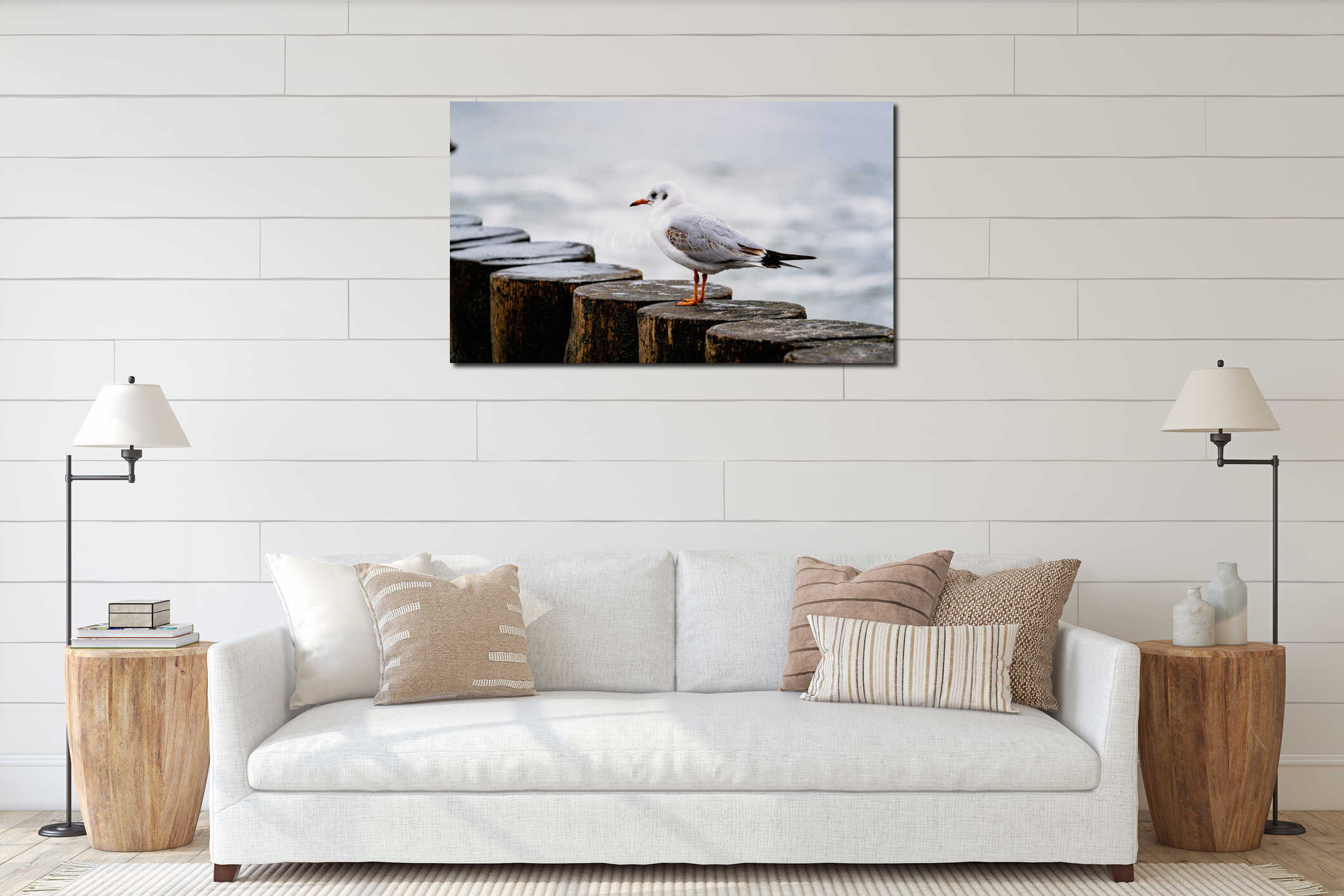 White seagull standing on wooden breakwater with calm ocean in background. Coastal bird on weathered wood pilings. Wildlife interior mockup