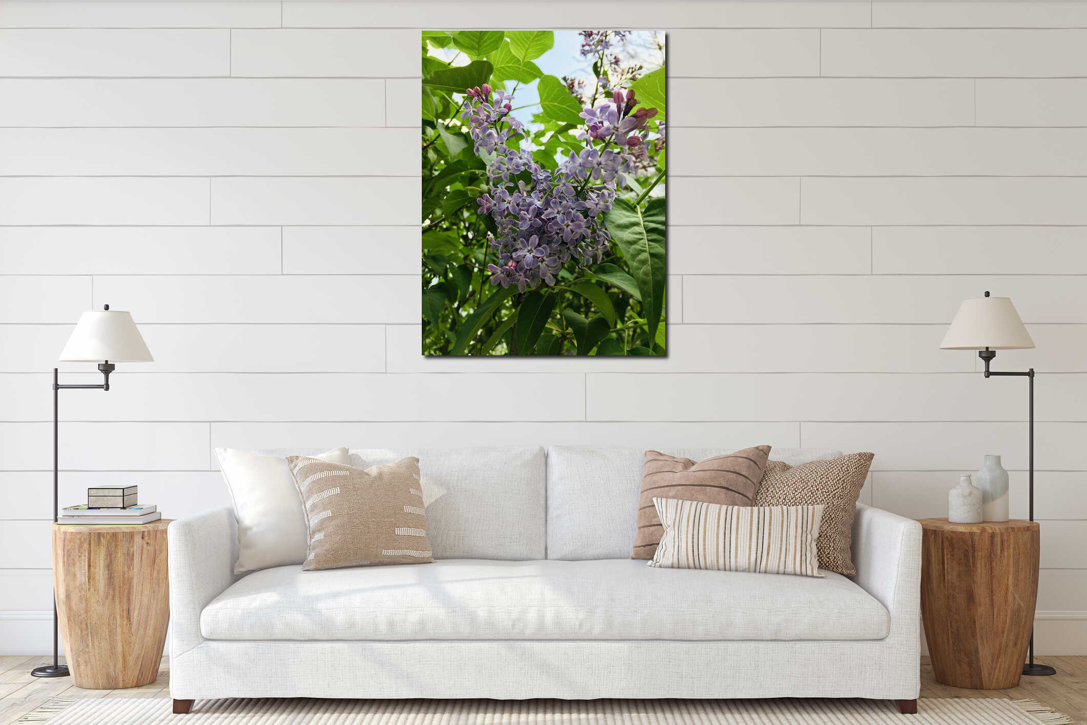 Light-purple lilac with four-petal flowers surrounded with green leaves creating natural pattern against blue sky vertical interior mockup