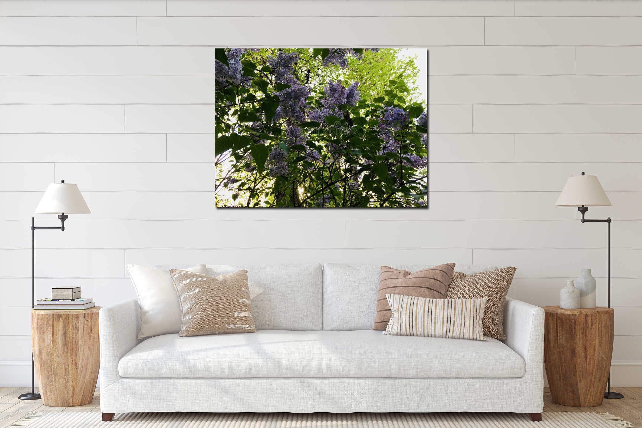 Light-purple lilac with four-petal flowers surrounded with green leaves creating natural pattern against light sky and trees interior mockup