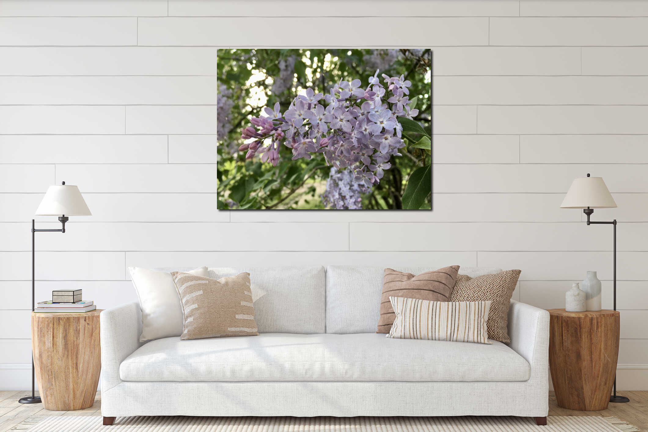 Light-purple lilac panicle blossoming with four-petal flowers and young green leaves horizontal closeup against light cloudy interior mockup
