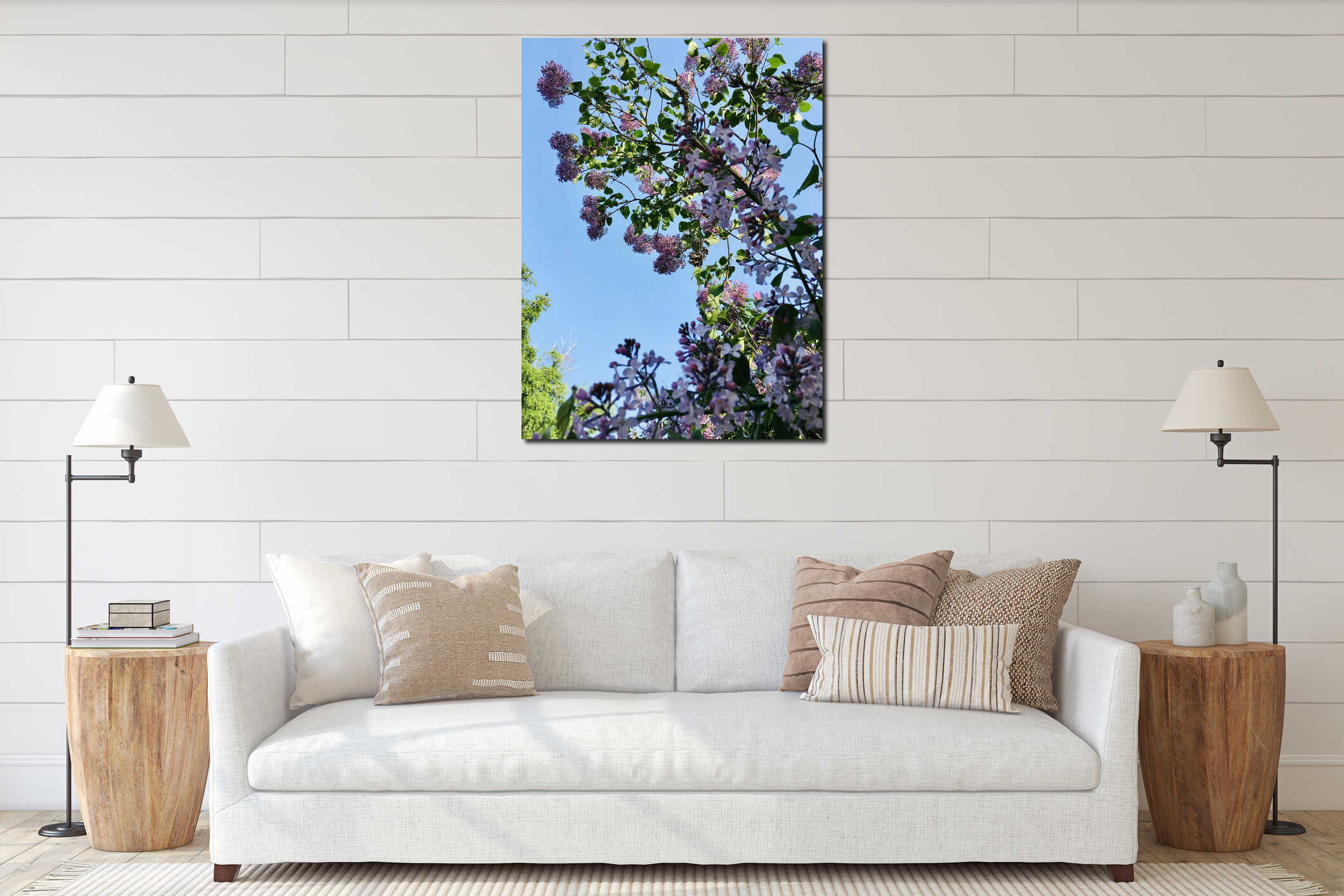 Light-purple lilac tree blossoming with four-petal flowers and young green leaves vertical low-angle closeup against light-blue interior mockup