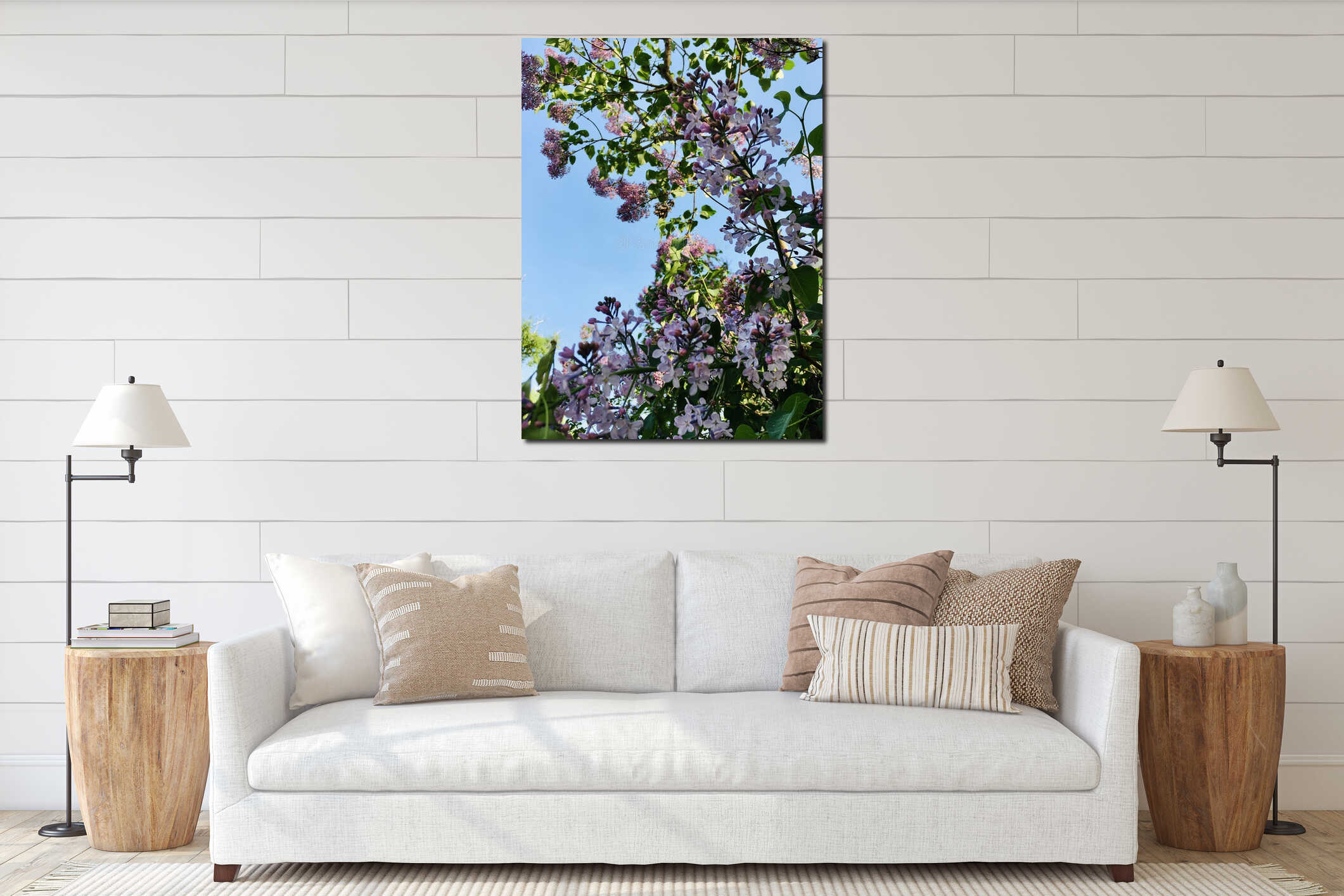 Light-purple lilac tree blossoming with four-petal flowers and young green leaves vertical low-angle closeup against light-blue interior mockup