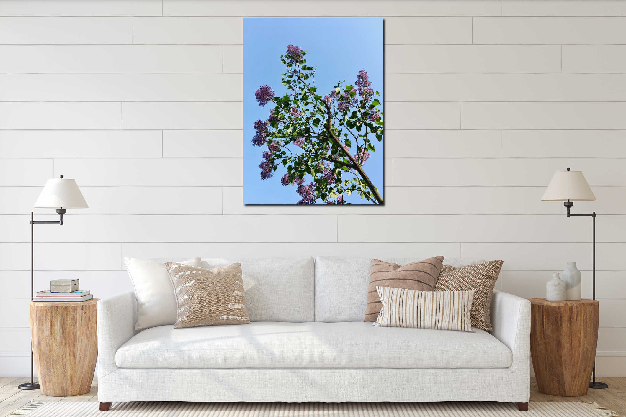 Light-purple lilac tree blossoming with four-petal flowers and young green leaves vertical low-angle closeup against light-blue interior mockup